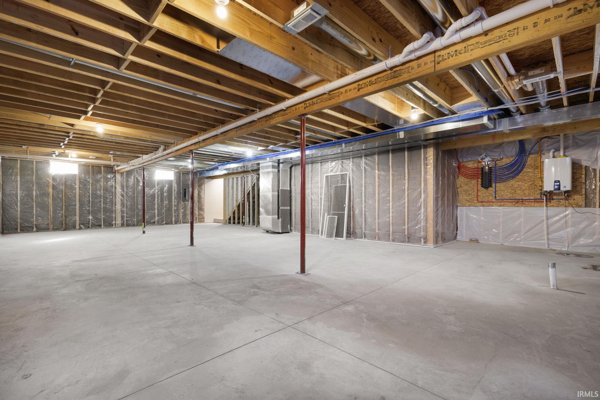 Unfinished basement featuring tankless water heater and heating unit