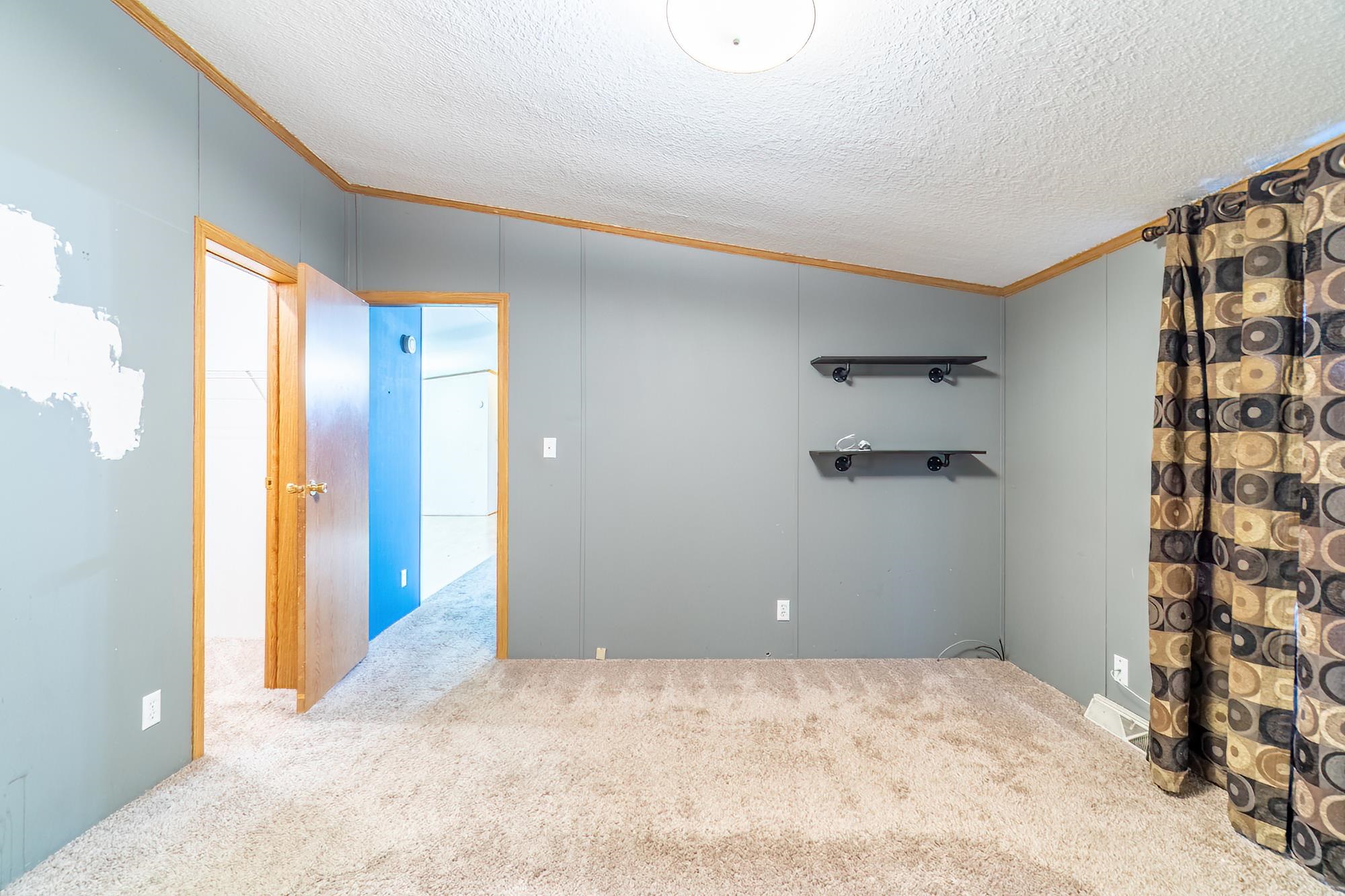 Spare room featuring crown molding, carpet flooring, and a textured ceiling
