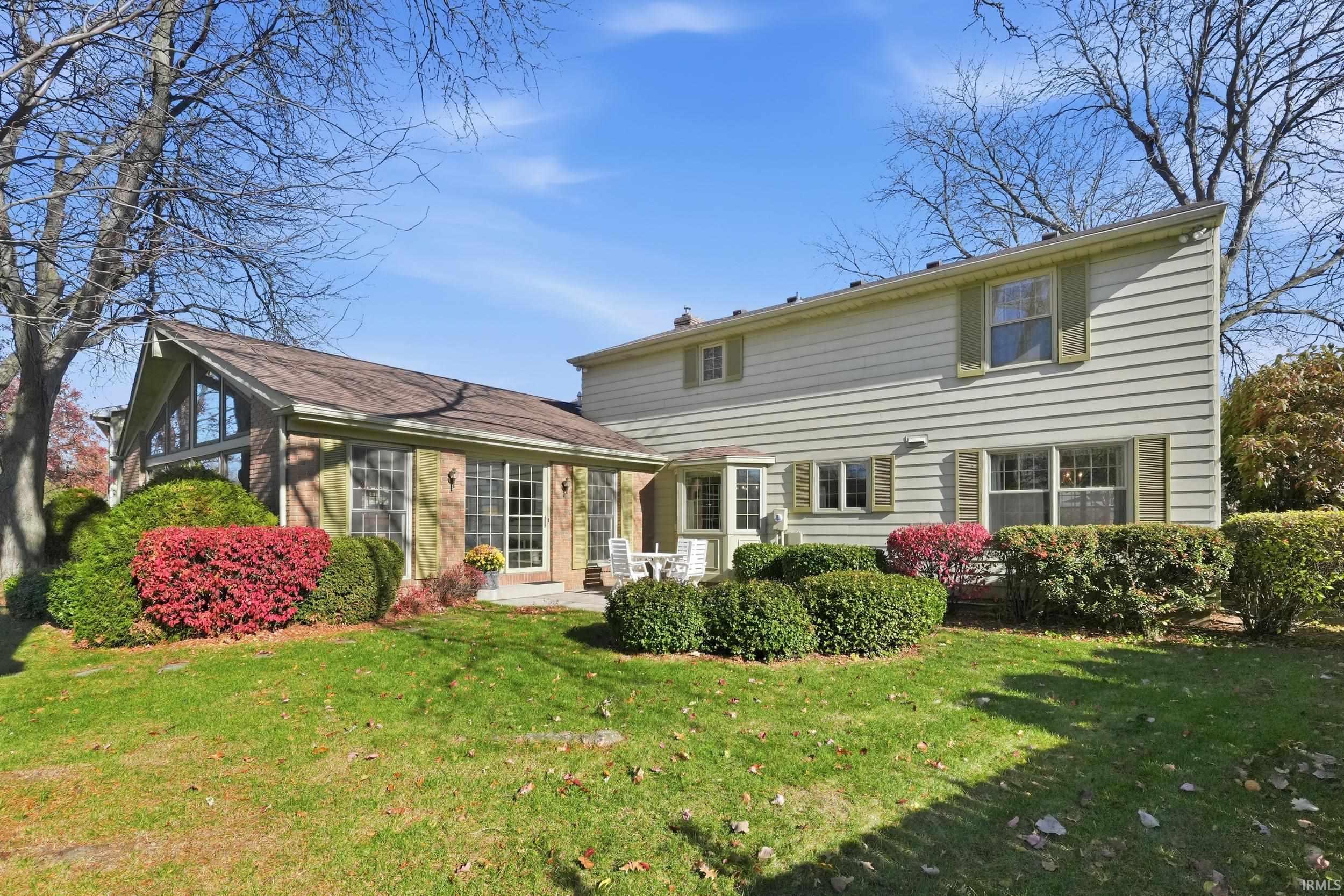 Rear view of property with a lawn and a patio area