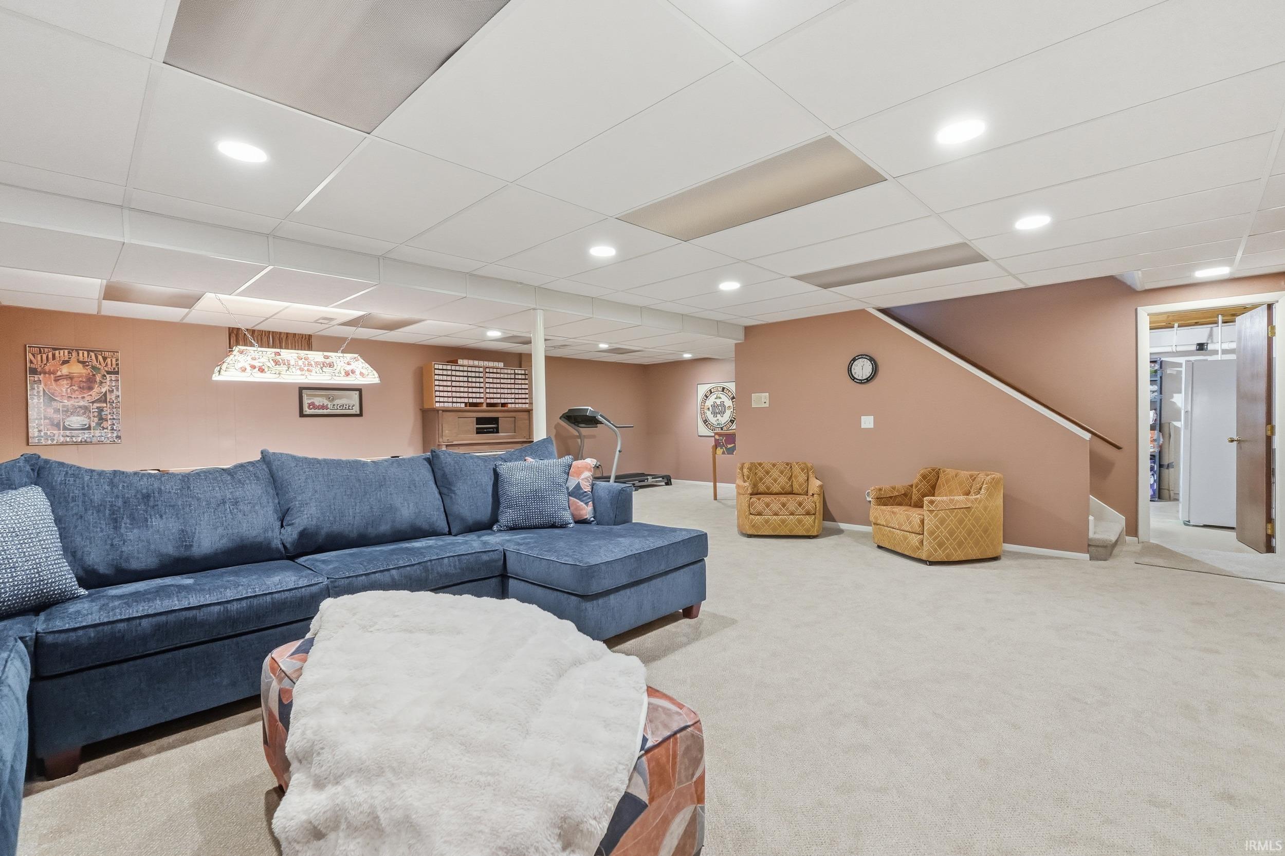 Carpeted living room with recessed lighting, stairway, and a paneled ceiling