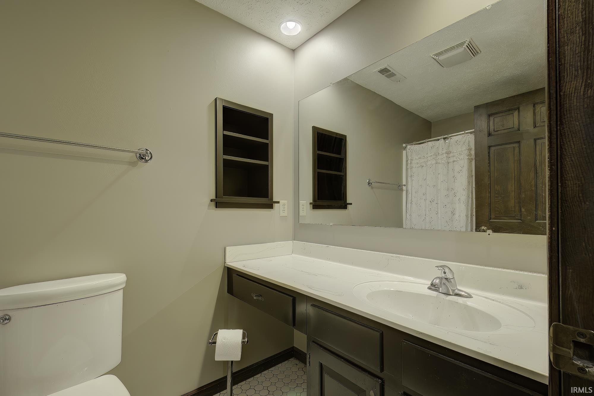 Bathroom with a shower with curtain and vanity