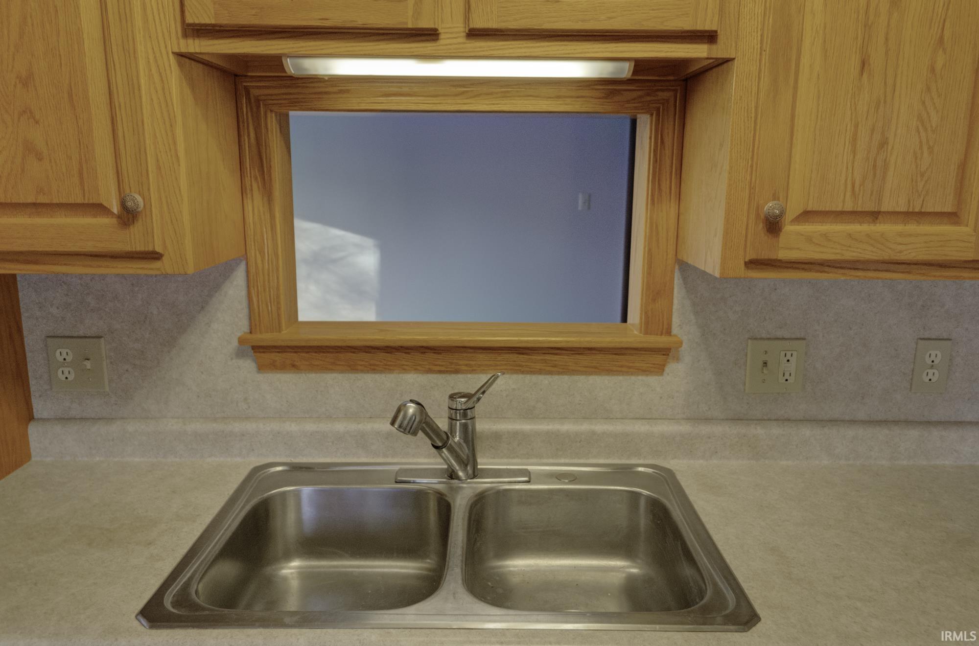 Kitchen view of light countertops and decorative backsplash