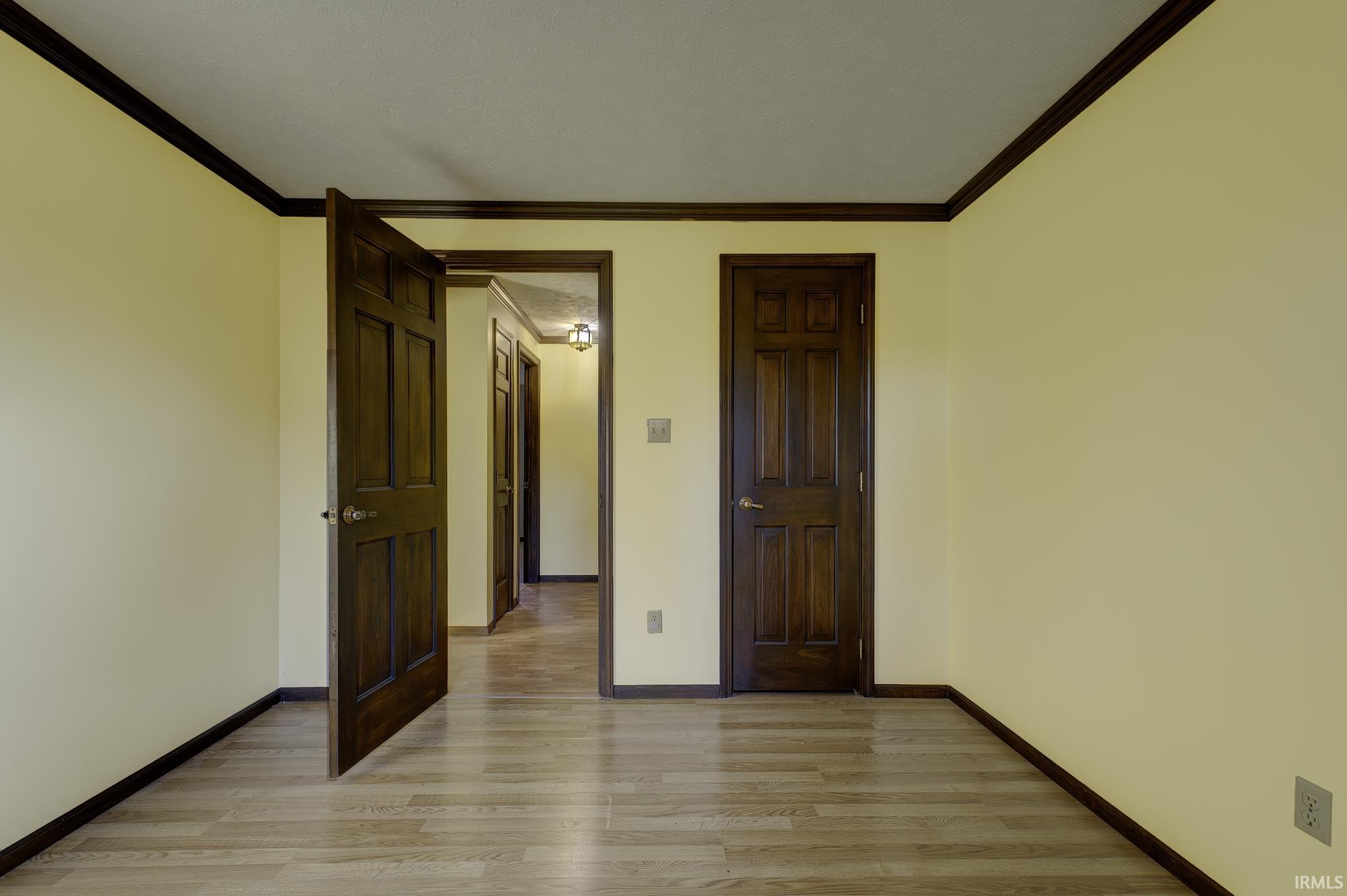 Unfurnished bedroom featuring ornamental molding and light wood finished floors