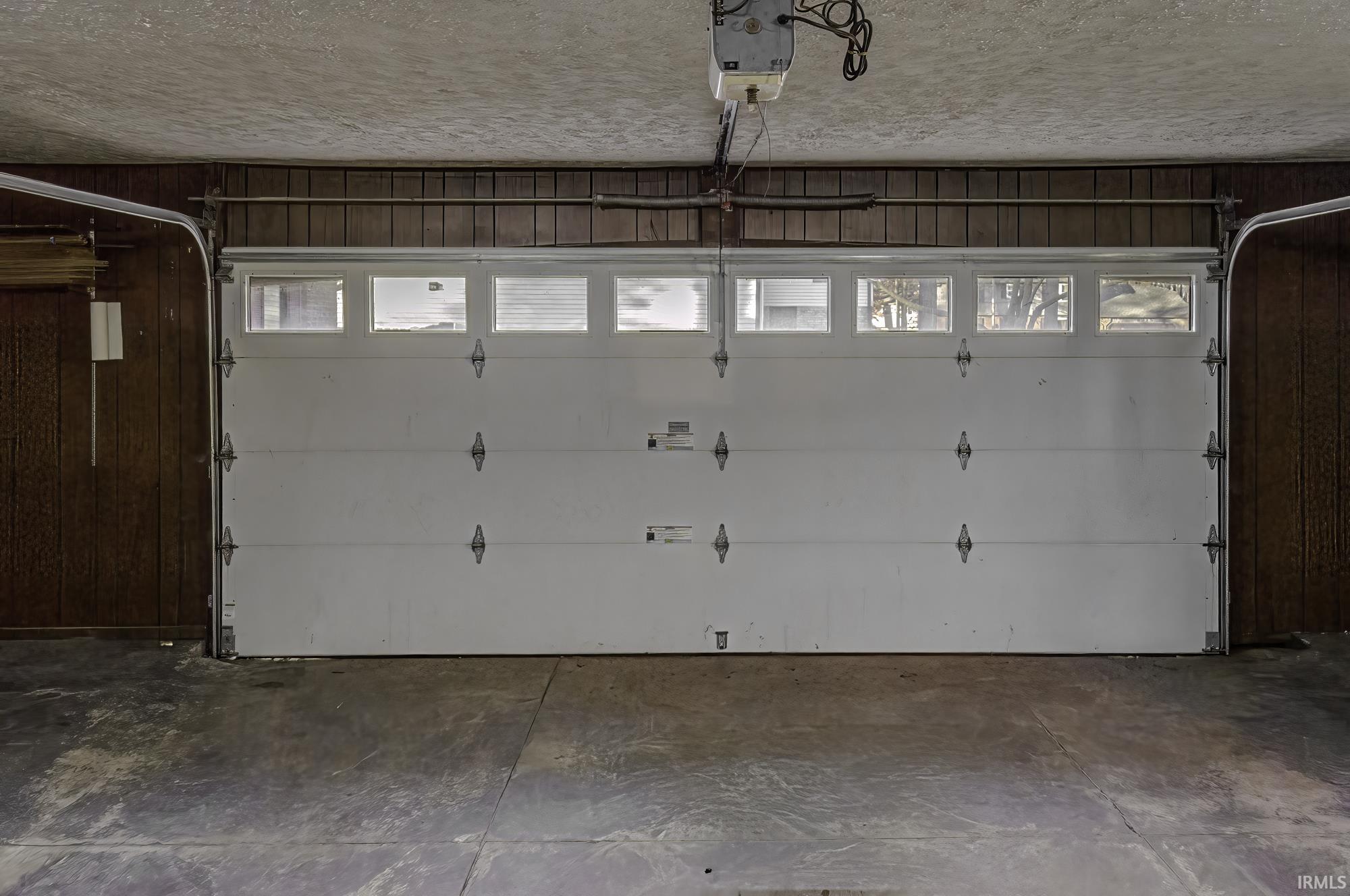 Garage featuring a garage door opener and wooden walls