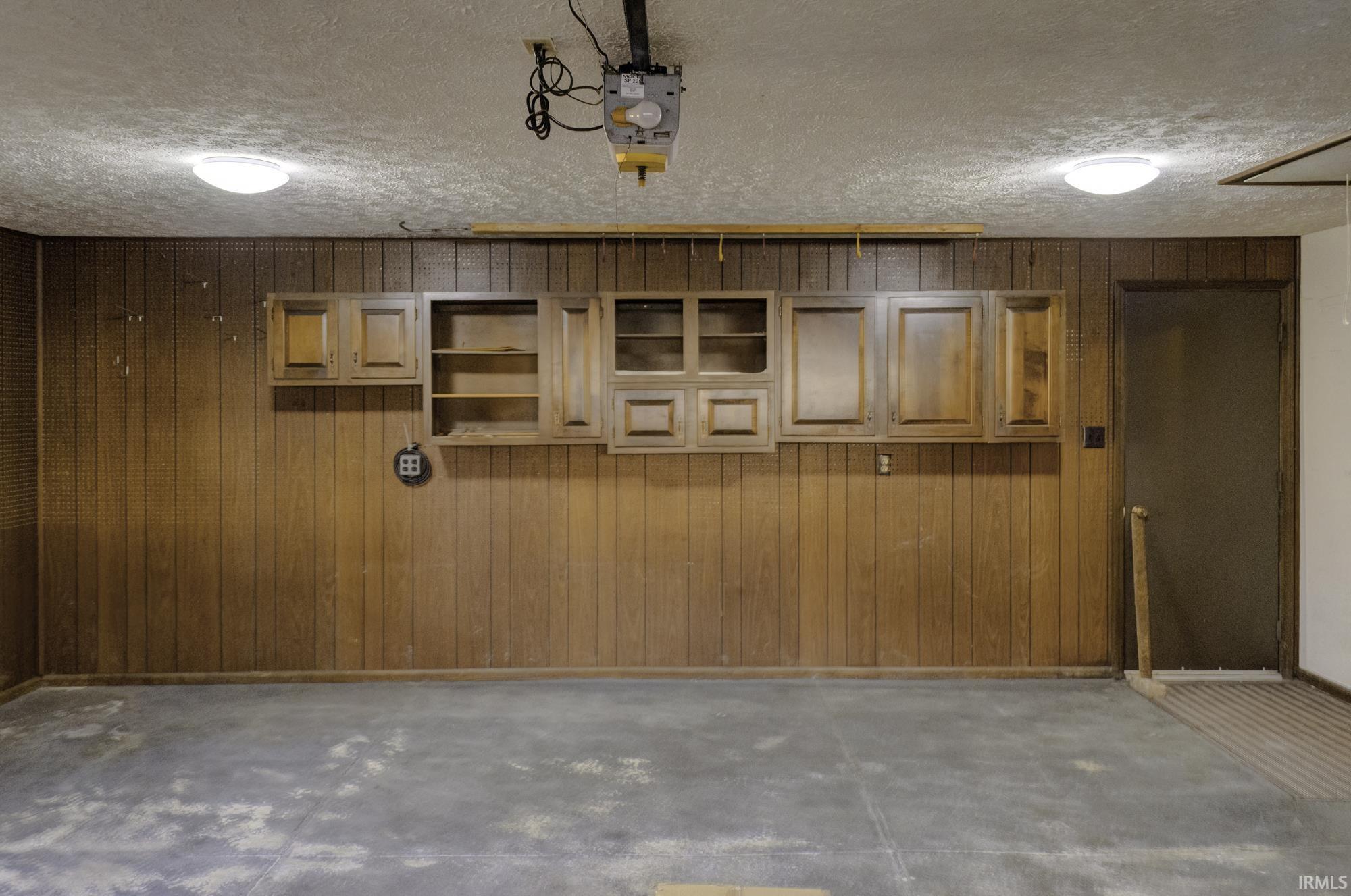 Interior space featuring wood walls and a garage door opener