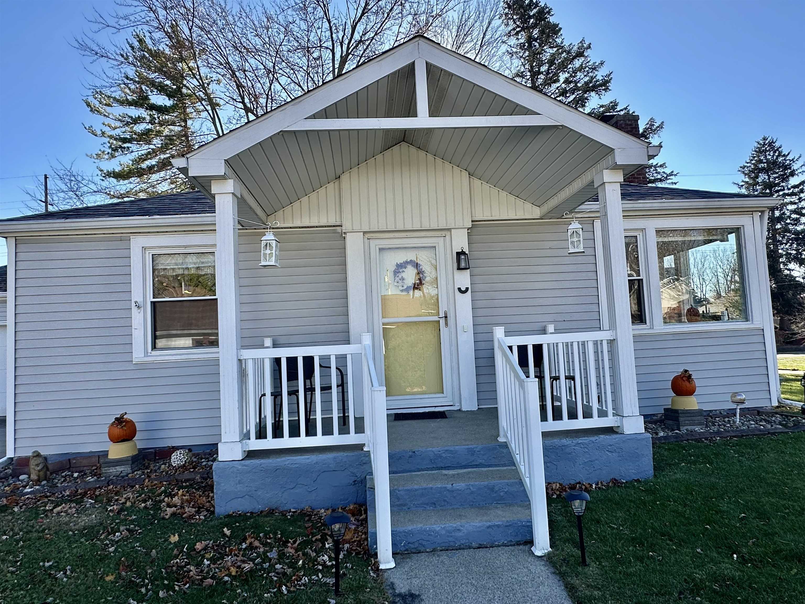 Property entrance with a yard and roof with shingles