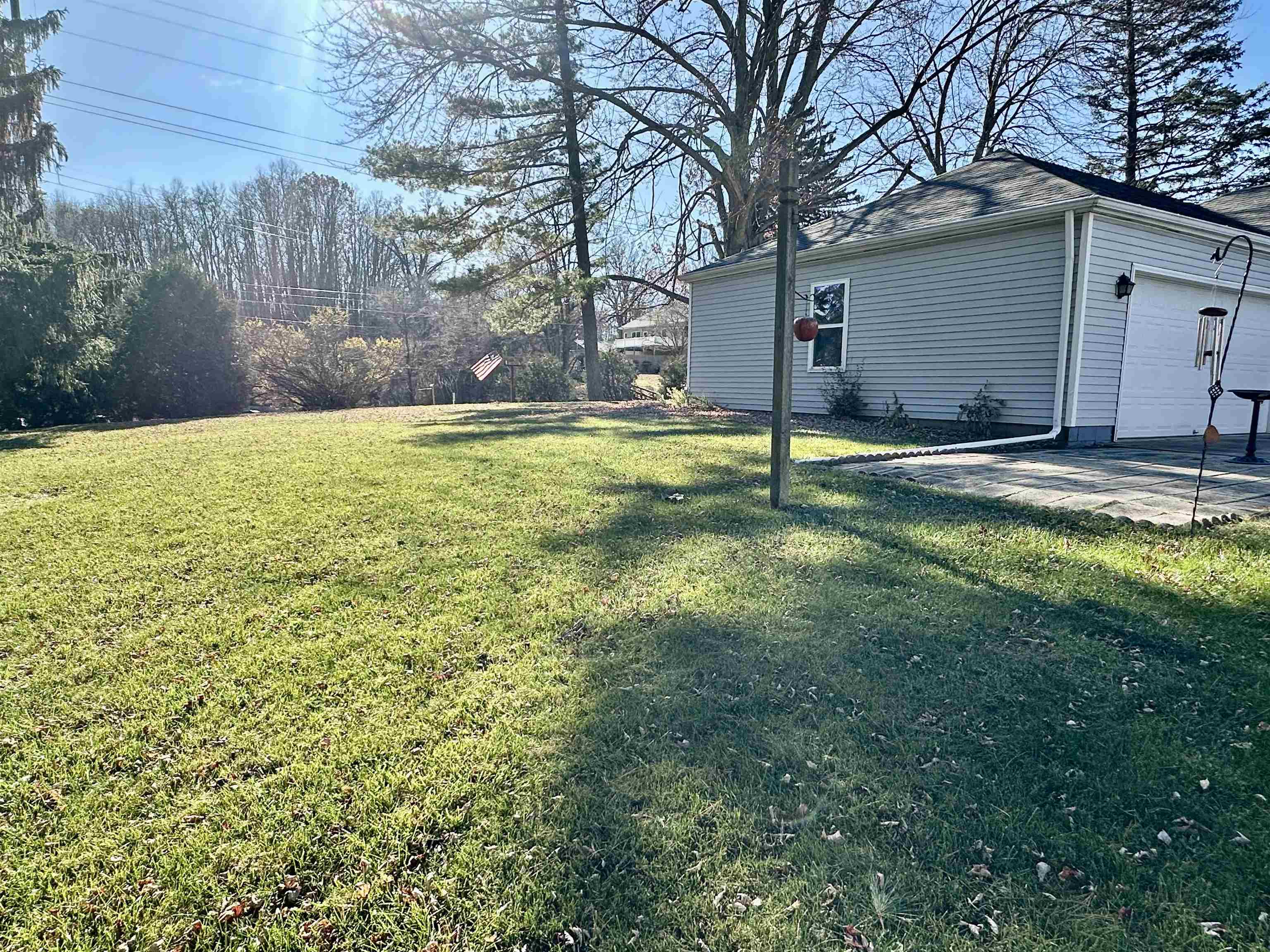 View of grassy yard with a patio area