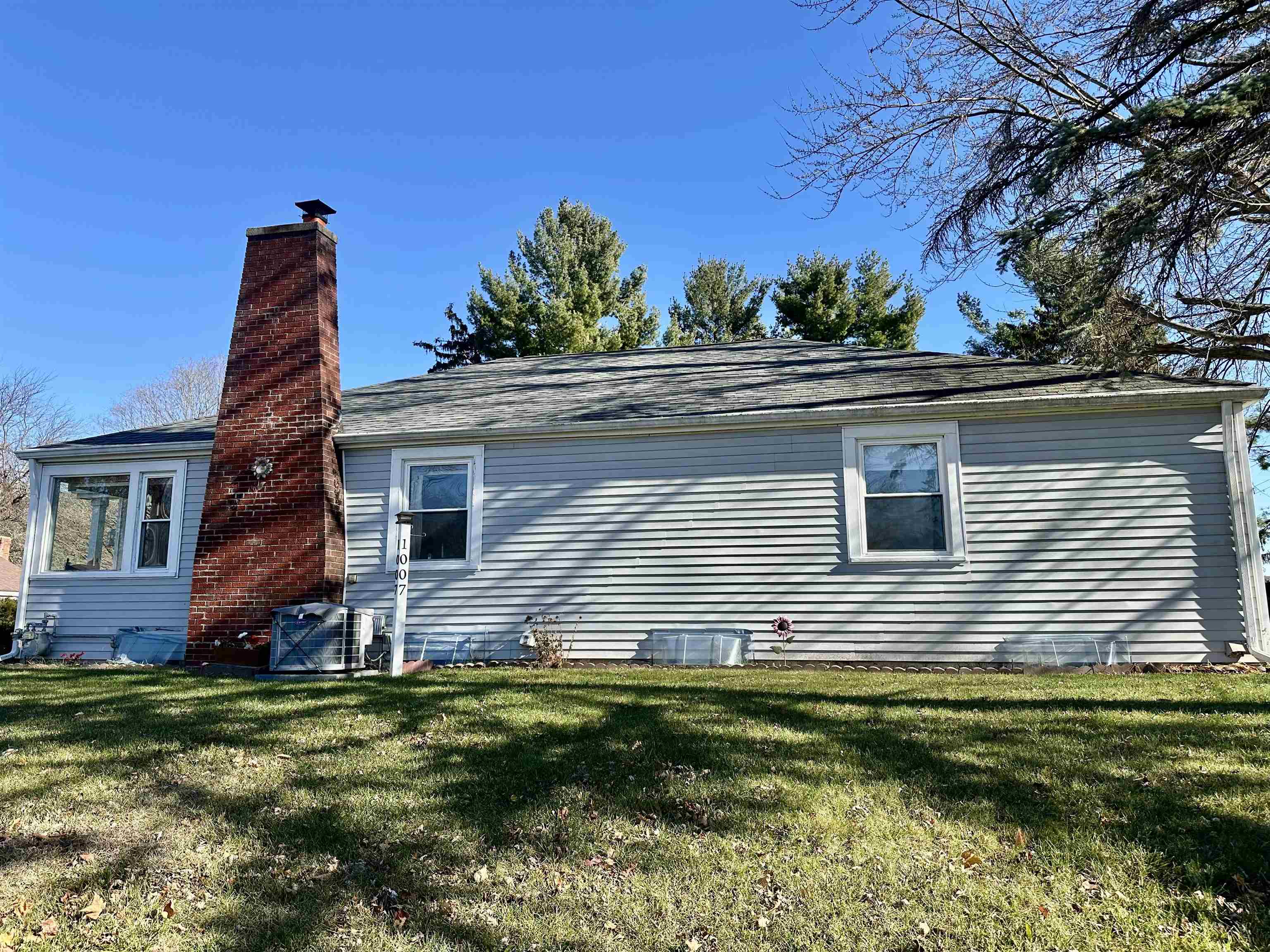 View of home's exterior featuring a yard and a chimney