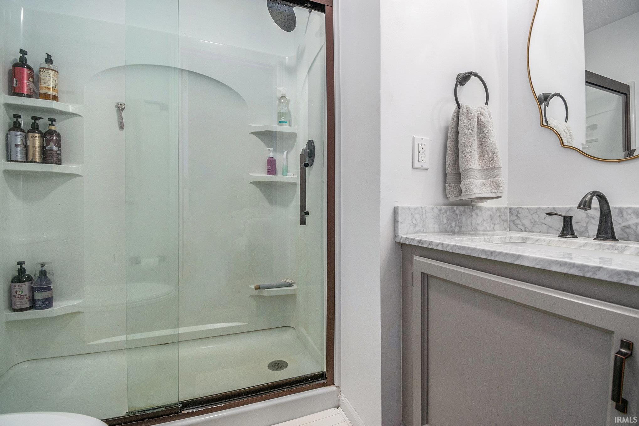 Full bathroom featuring vanity and a shower stall