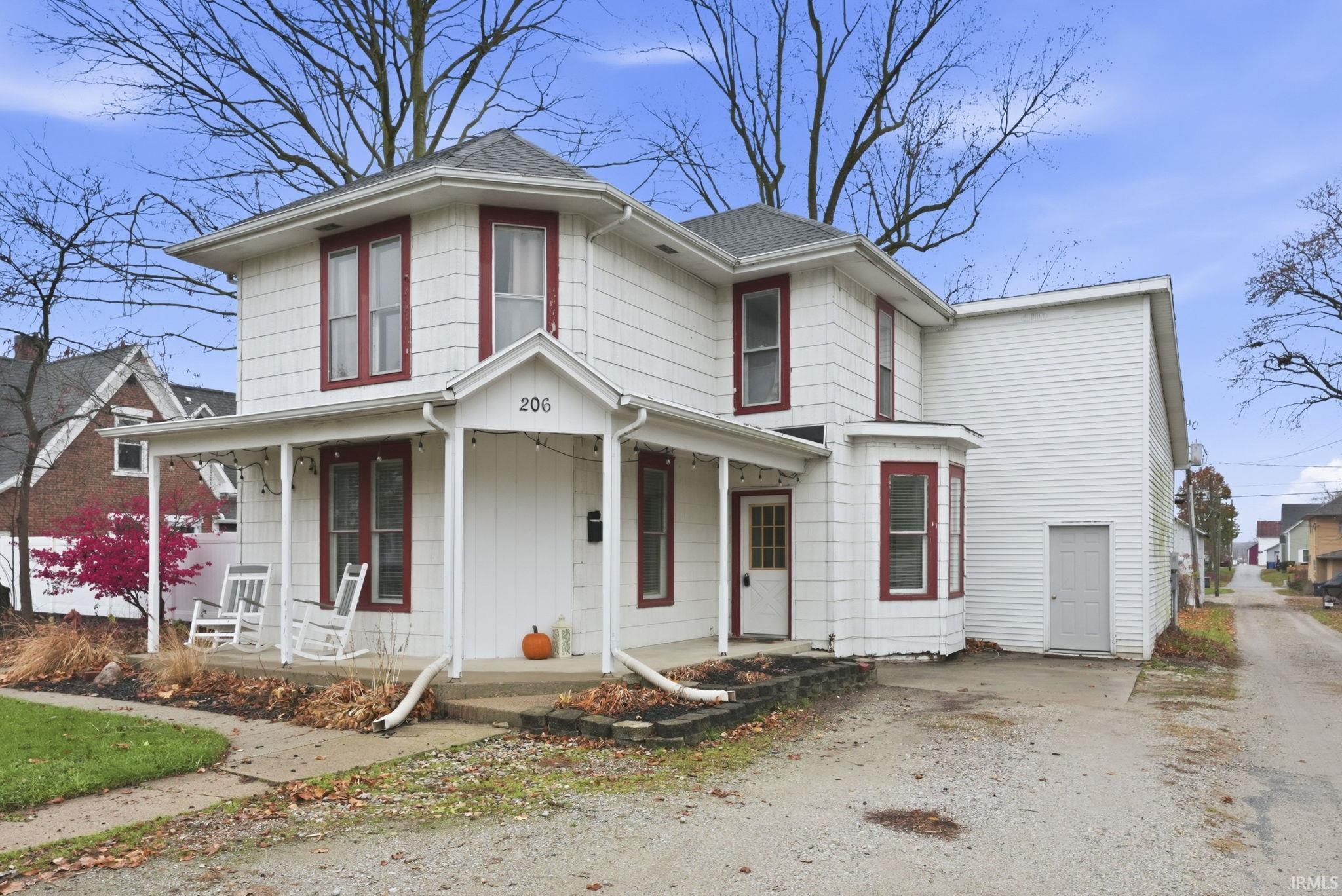 View of front of property with covered porch and a shingled roof