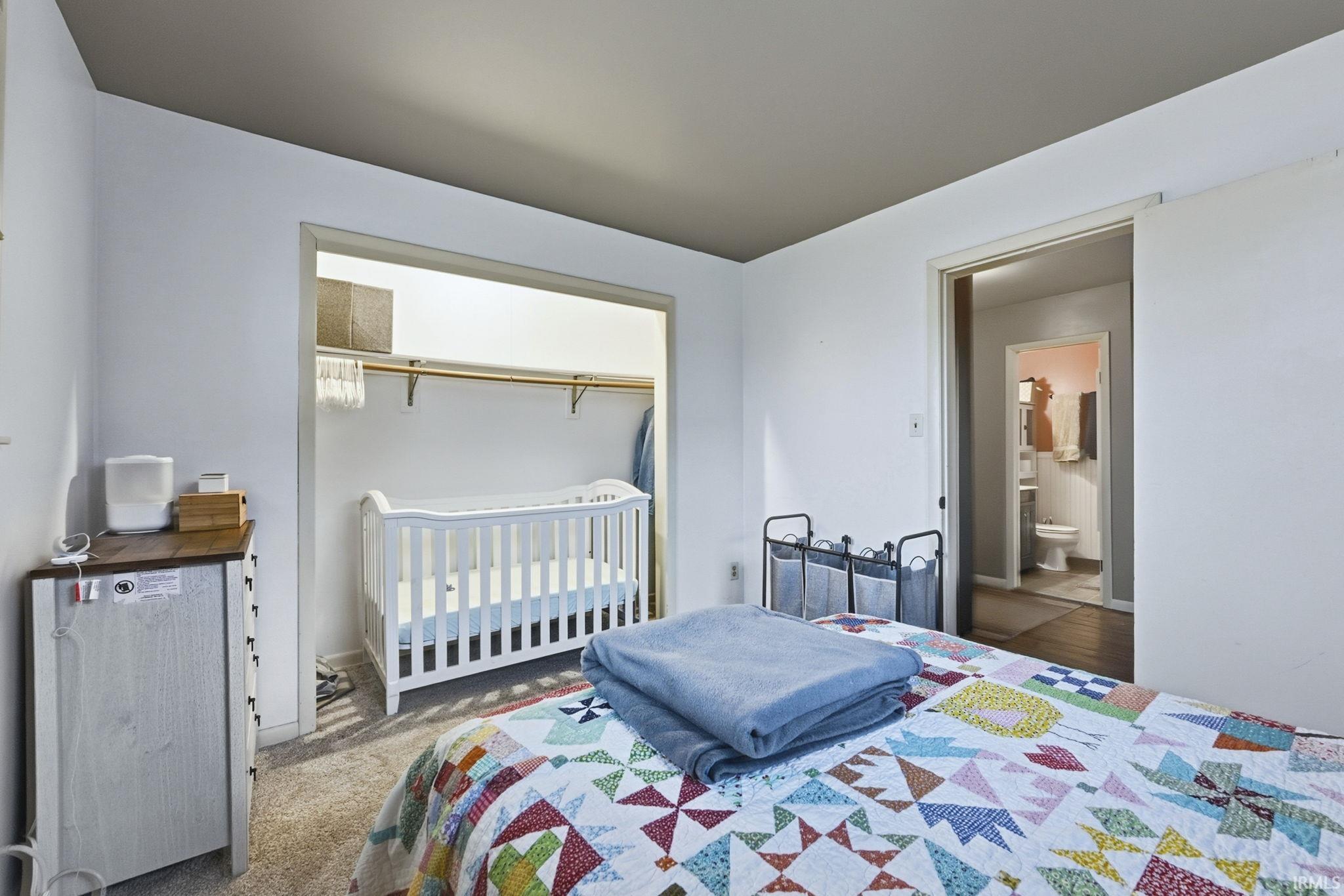 Bedroom with a nursery area and carpet