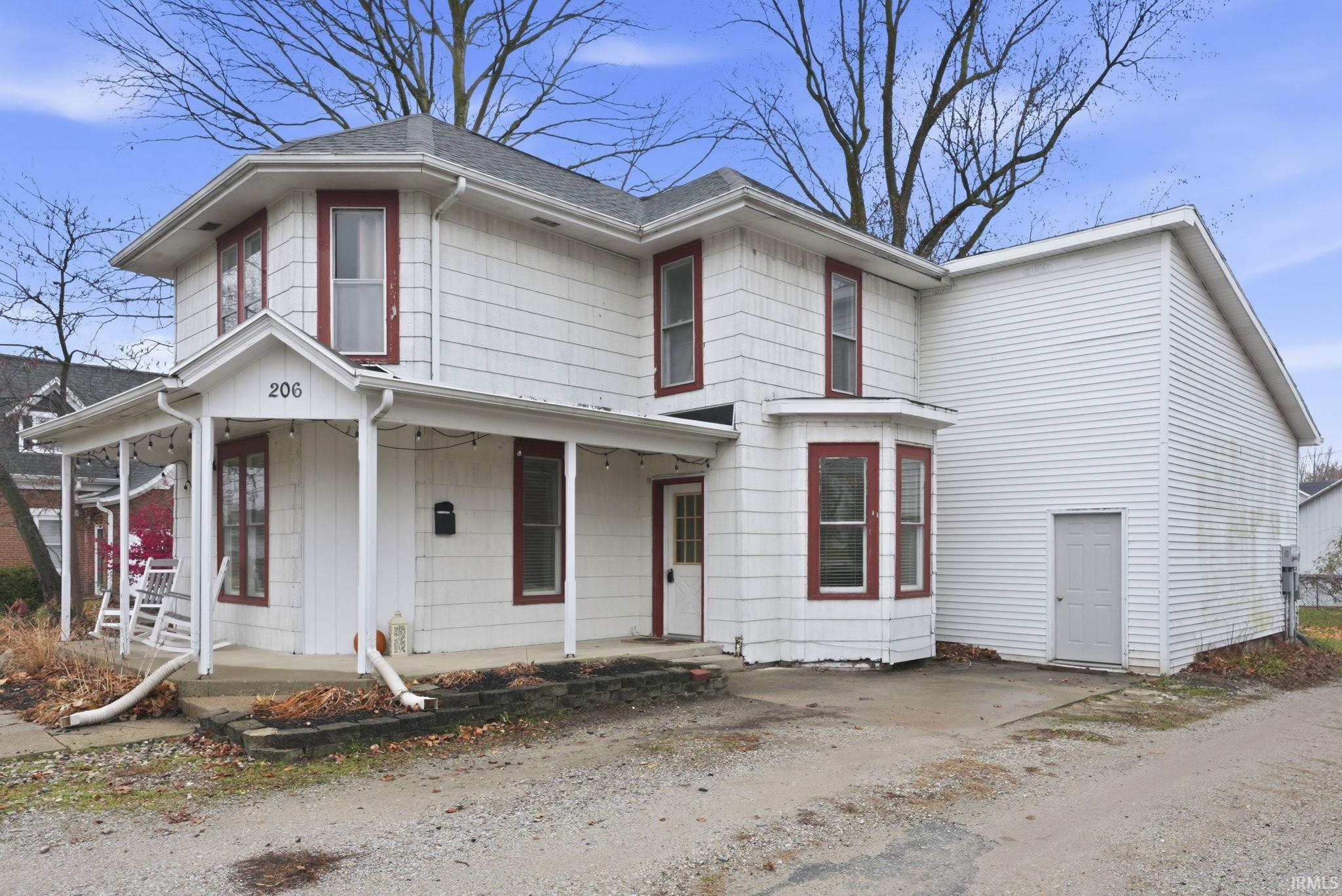 View of front facade featuring covered porch and roof with shingles