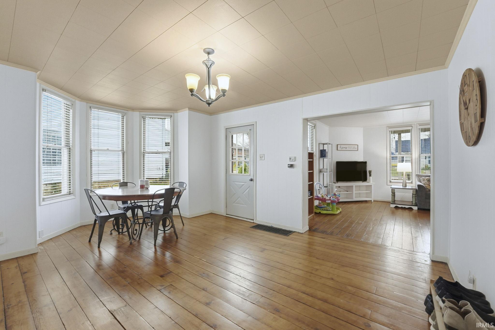 Dining space featuring light wood finished floors, a chandelier, and ornamental molding