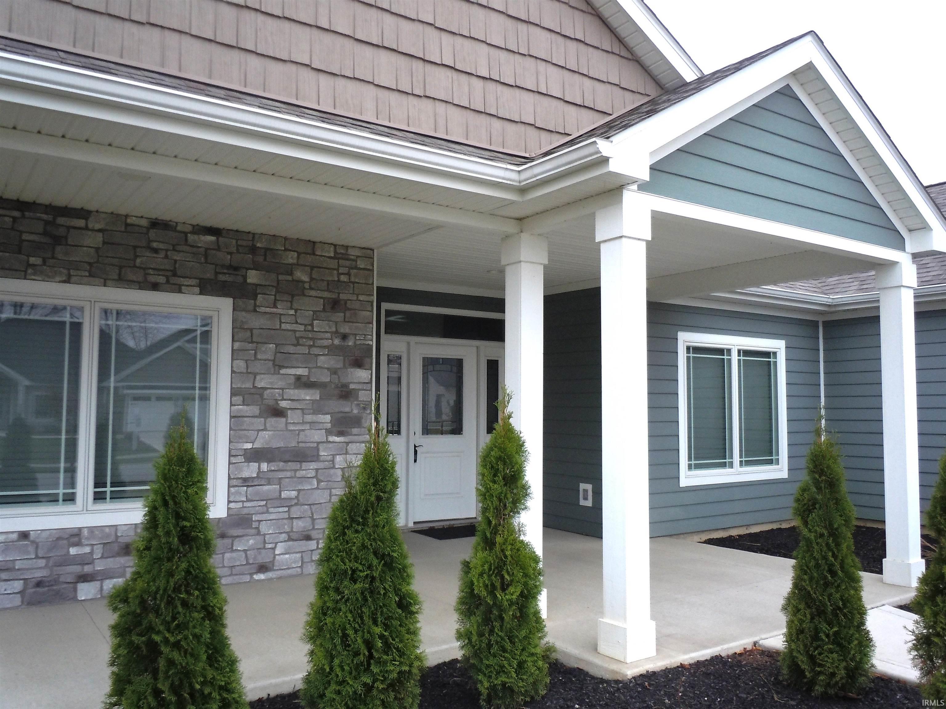 Doorway to property featuring stone siding and a porch
