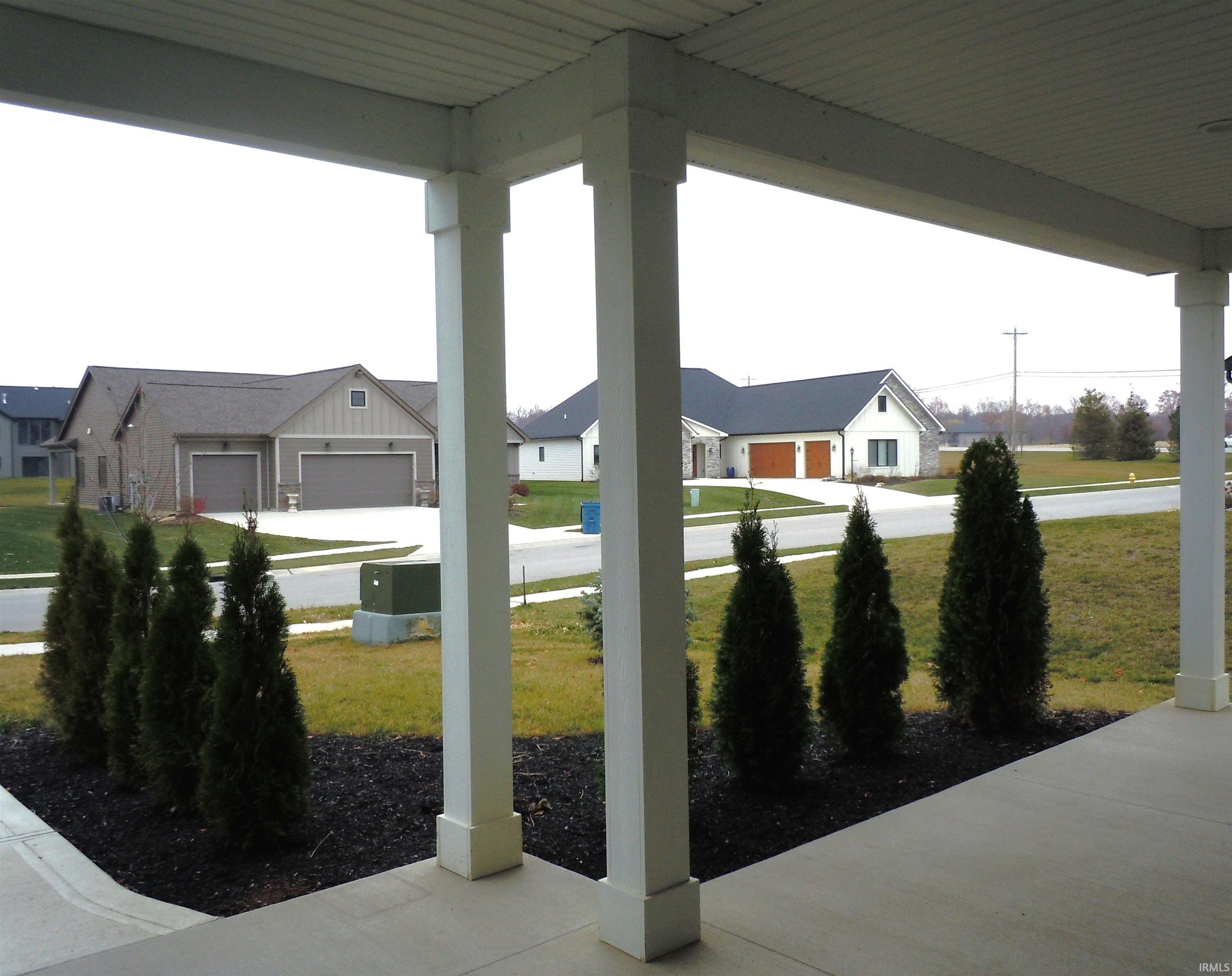 Porch featuring a lawn, a residential view, and a garage