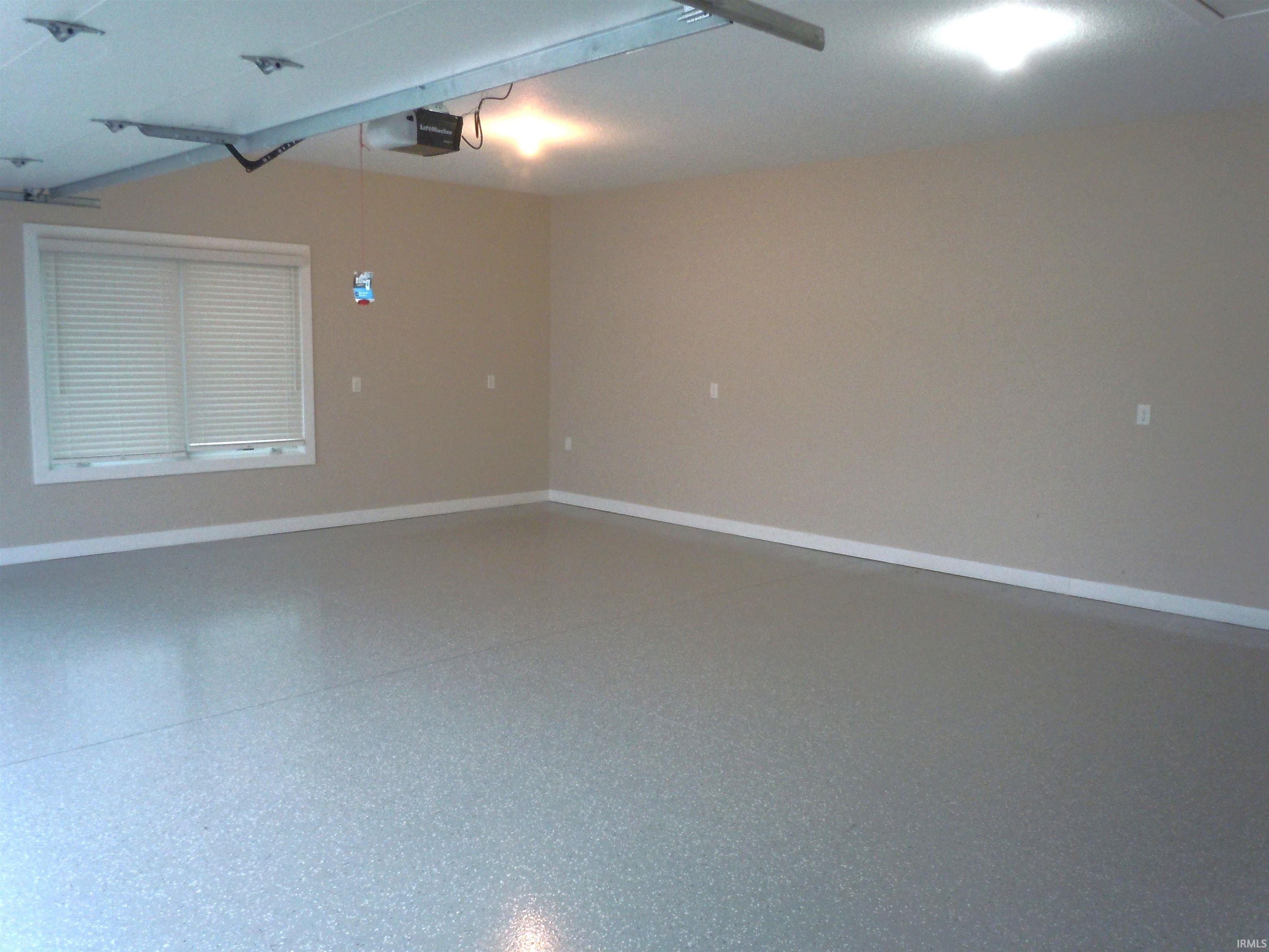 Spare room featuring speckled floor and baseboards
