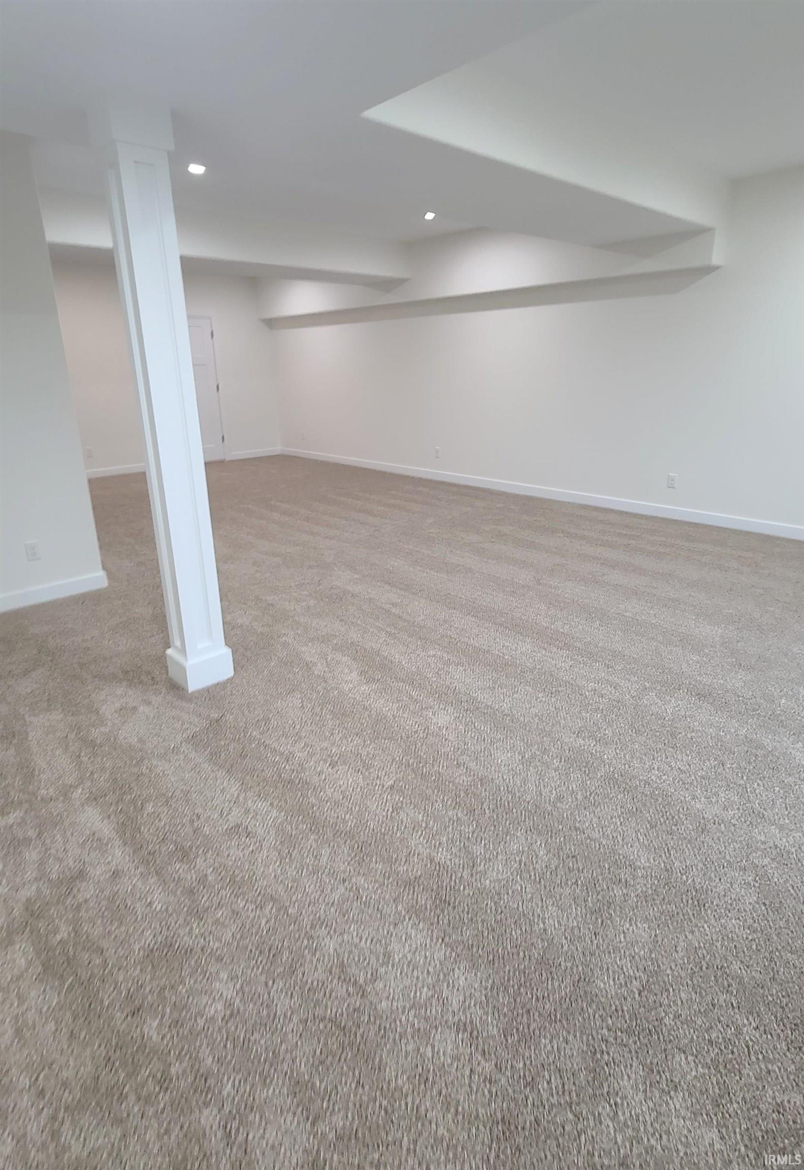 Finished below grade area featuring light carpet and recessed lighting