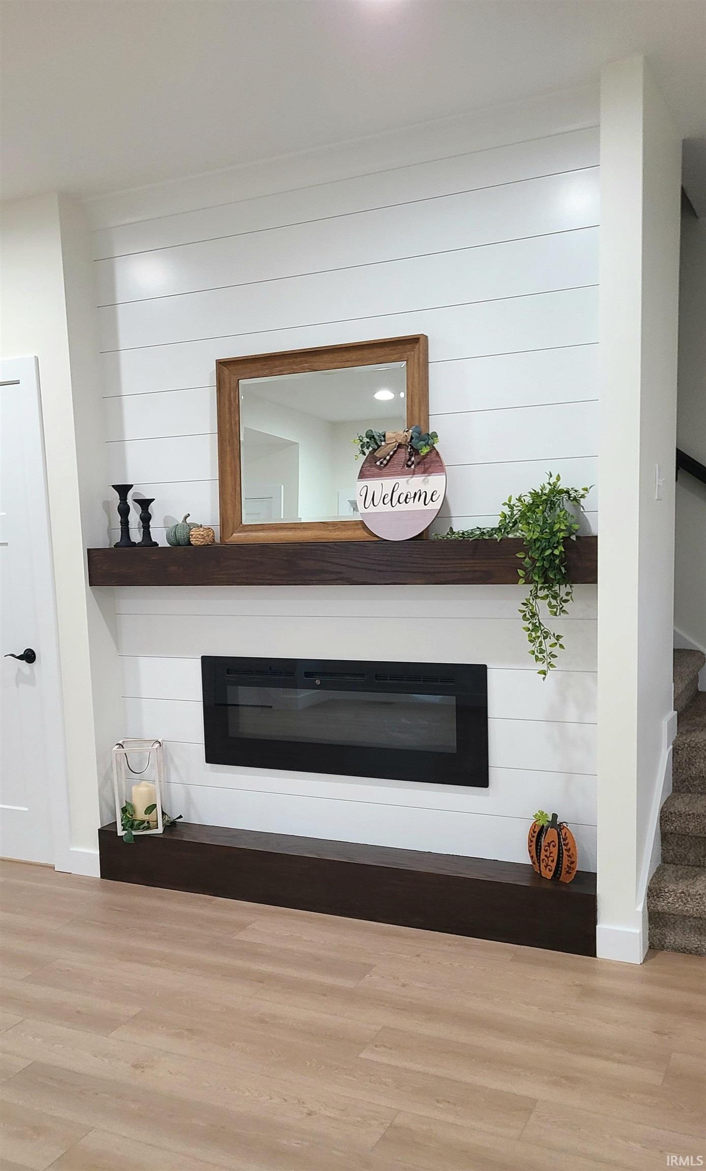Detailed view of a glass covered fireplace and wood finished floors