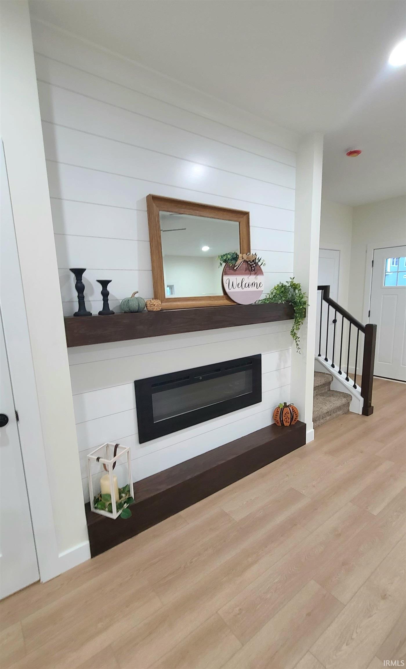 Detailed view of a glass covered fireplace and wood finished floors
