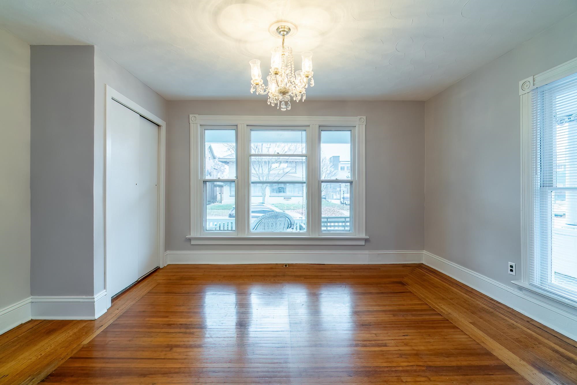 Unfurnished dining area featuring wood-type flooring and a chandelier