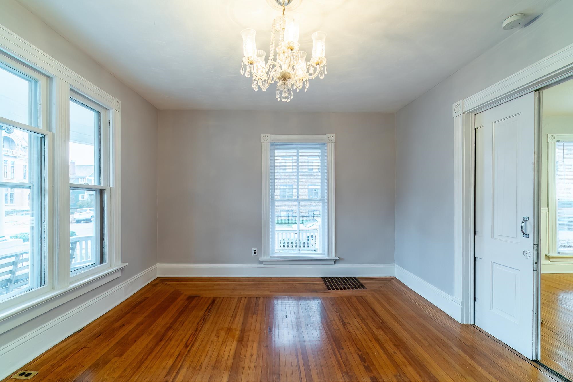 Spare room featuring hardwood / wood-style flooring and a chandelier