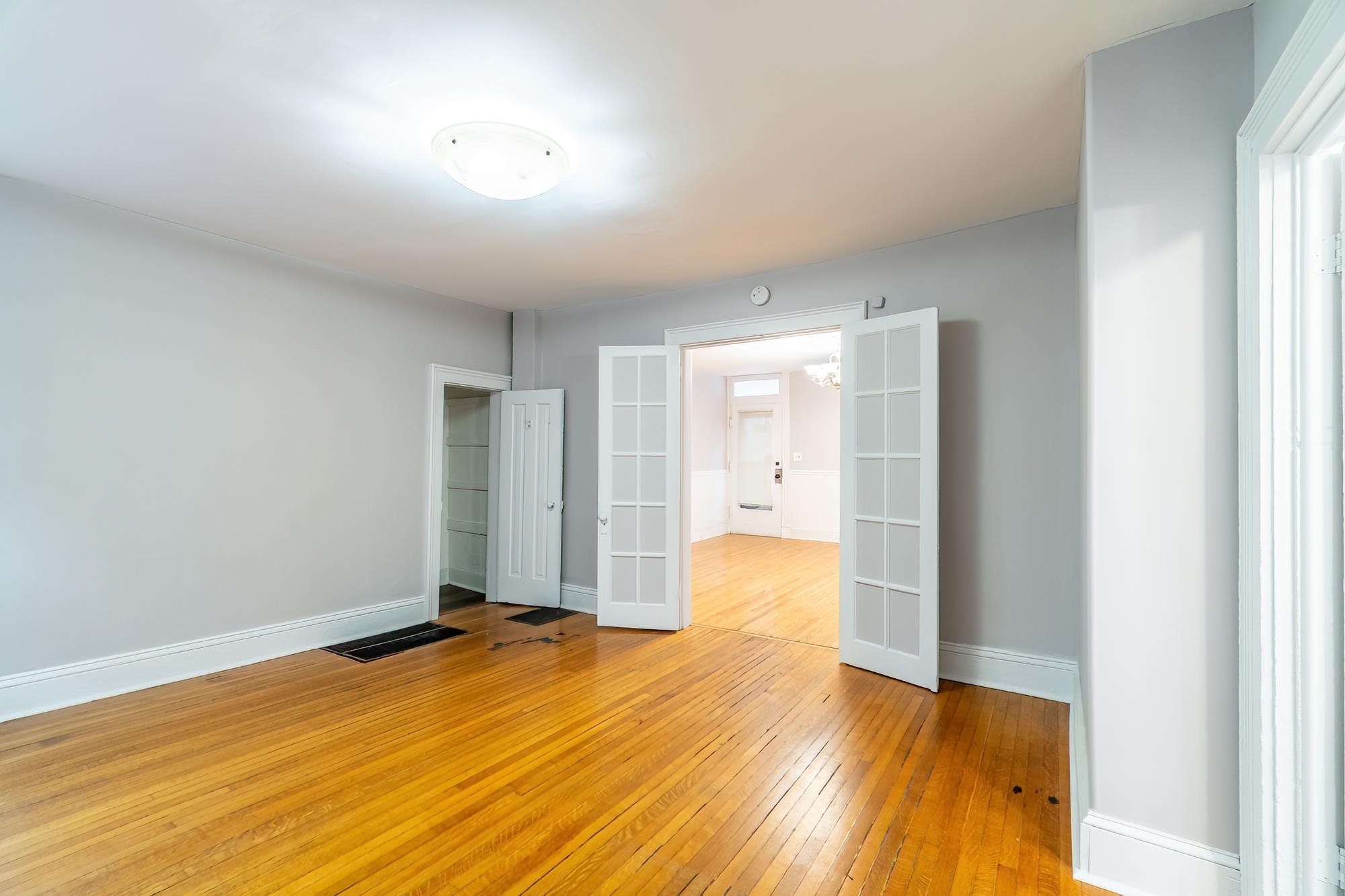 Unfurnished bedroom featuring french doors and light wood-style flooring