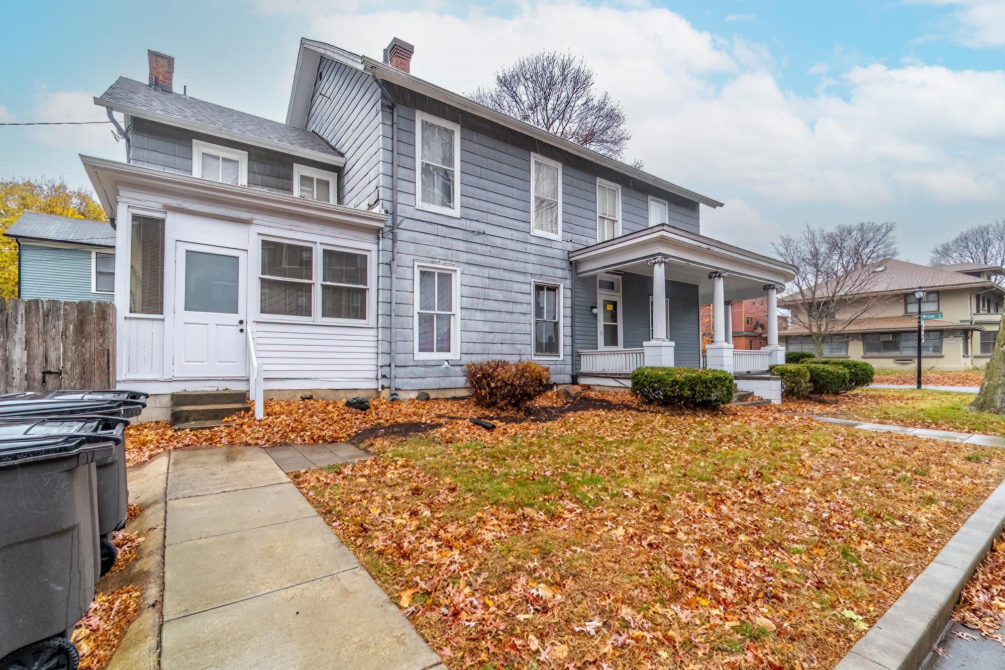 View of front of property with a chimney and a porch