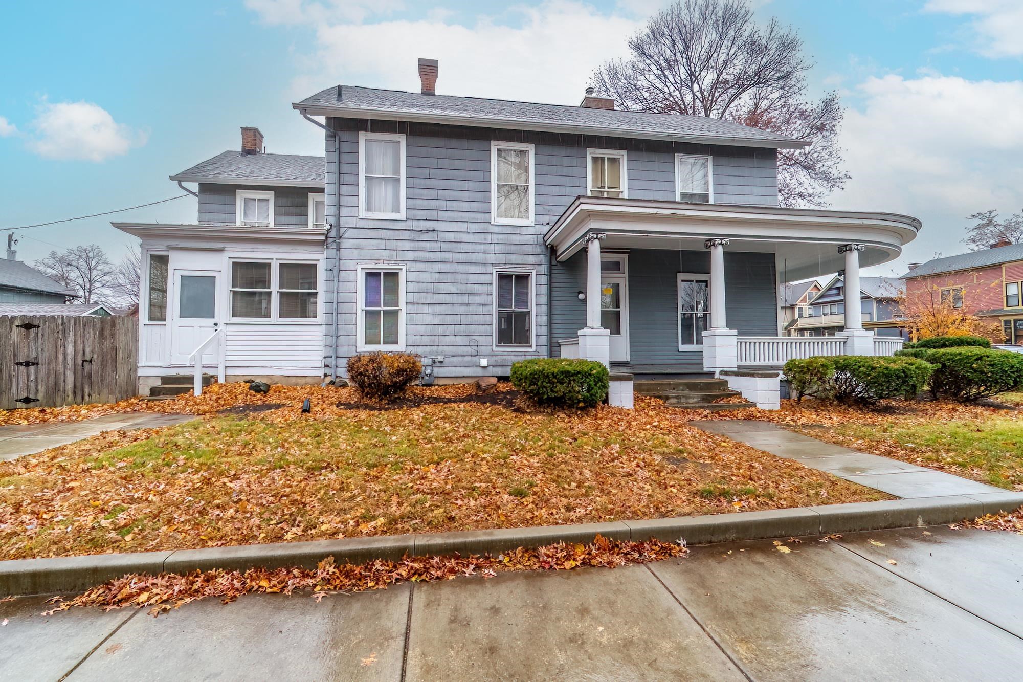 View of front of house featuring a chimney and a porch