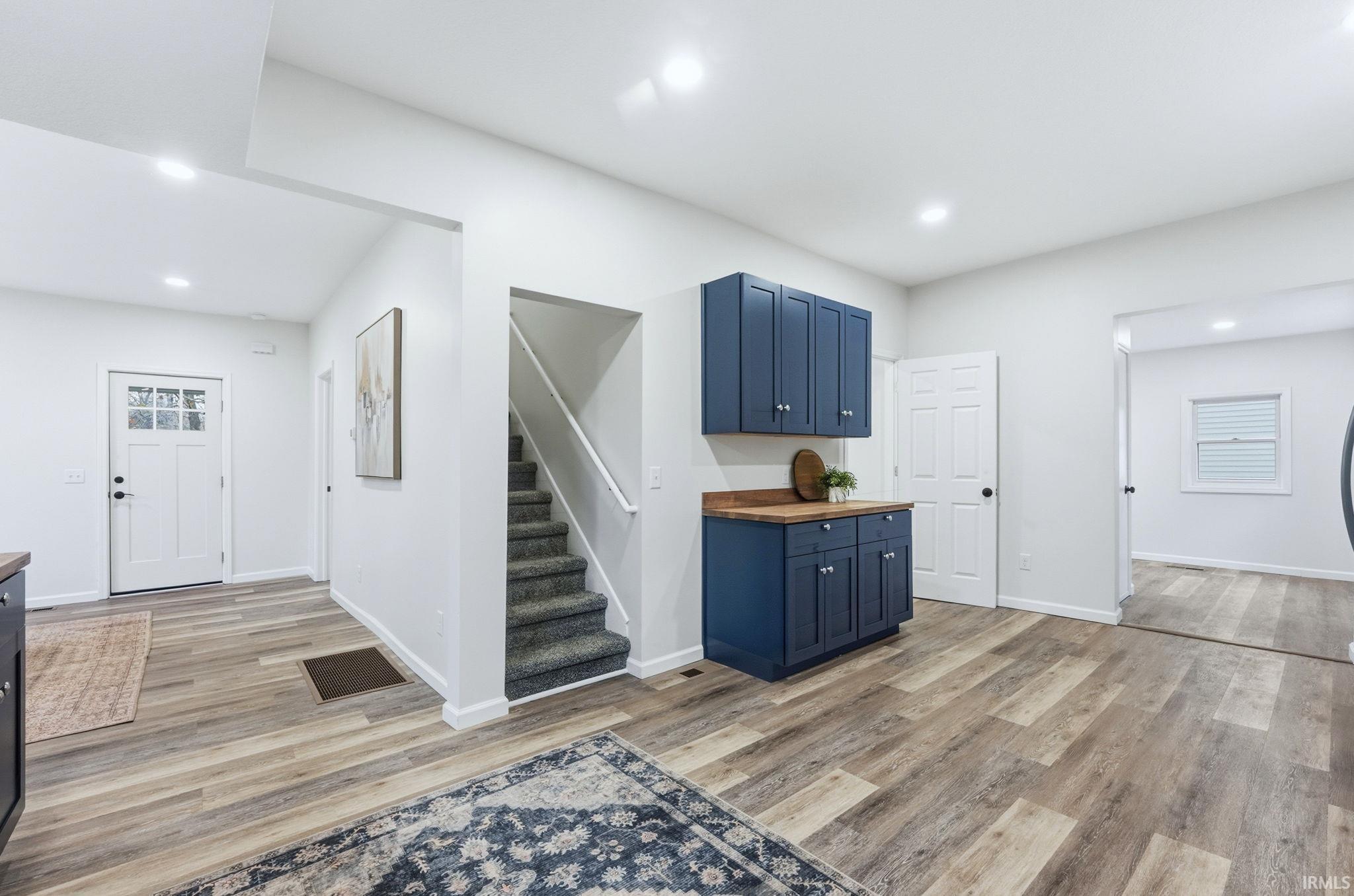 Entryway featuring recessed lighting, light wood-style floors, and stairs