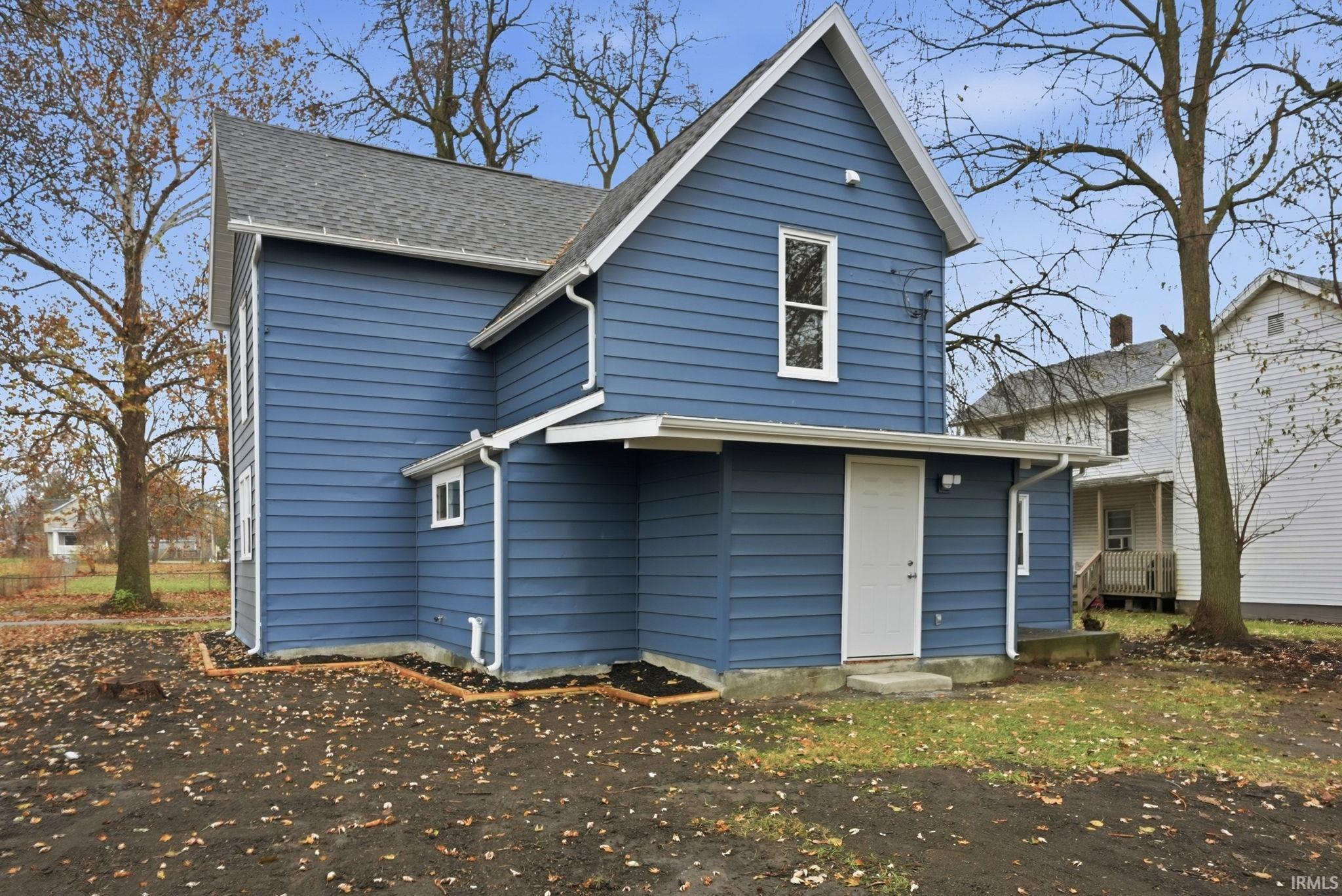 Rear view of house featuring roof with shingles
