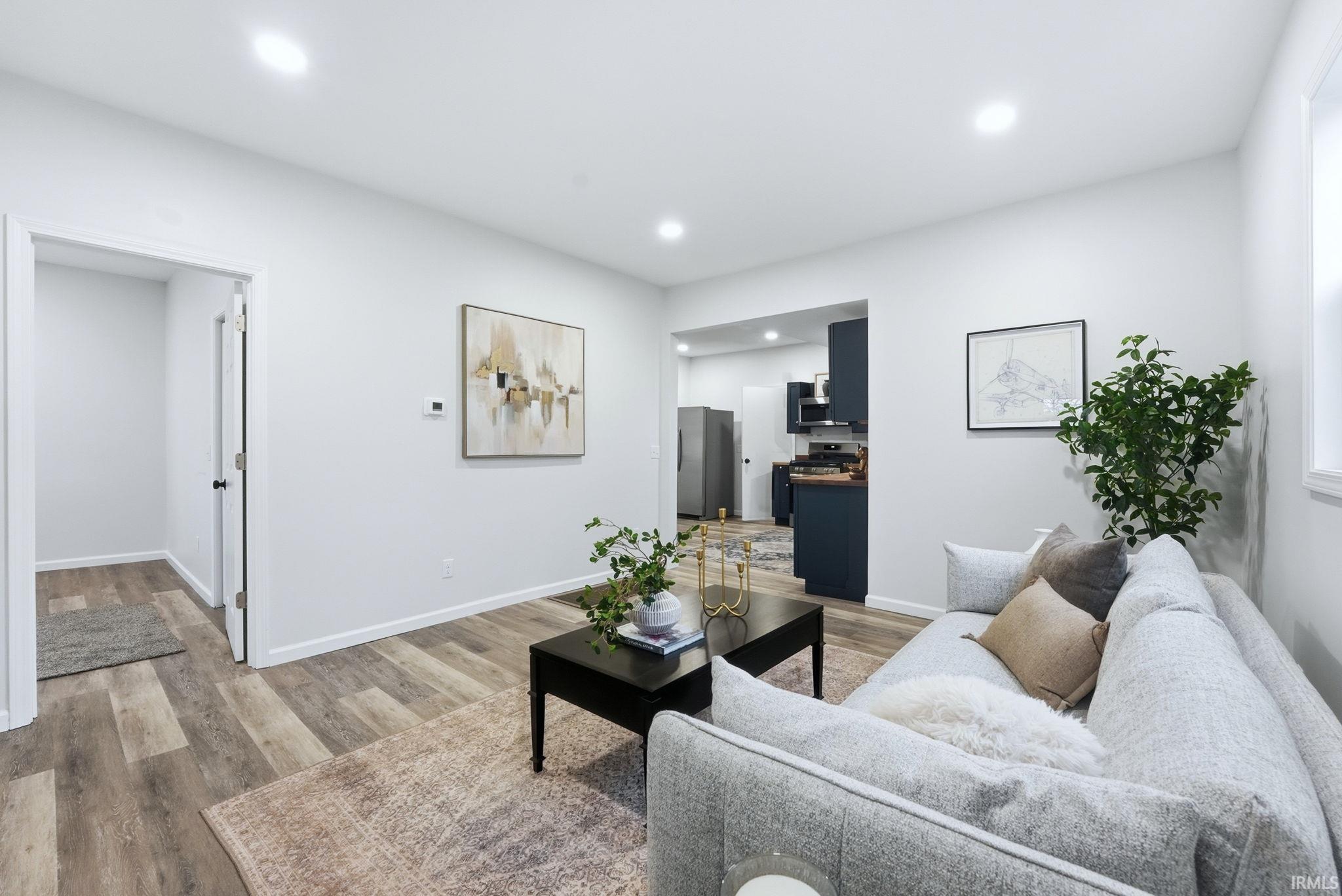 Living room with light wood-style floors and recessed lighting