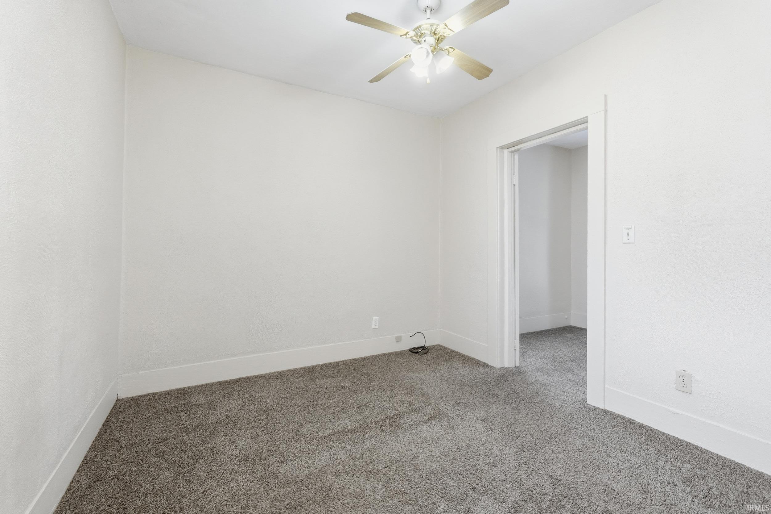 Unfurnished room featuring carpet and ceiling fan