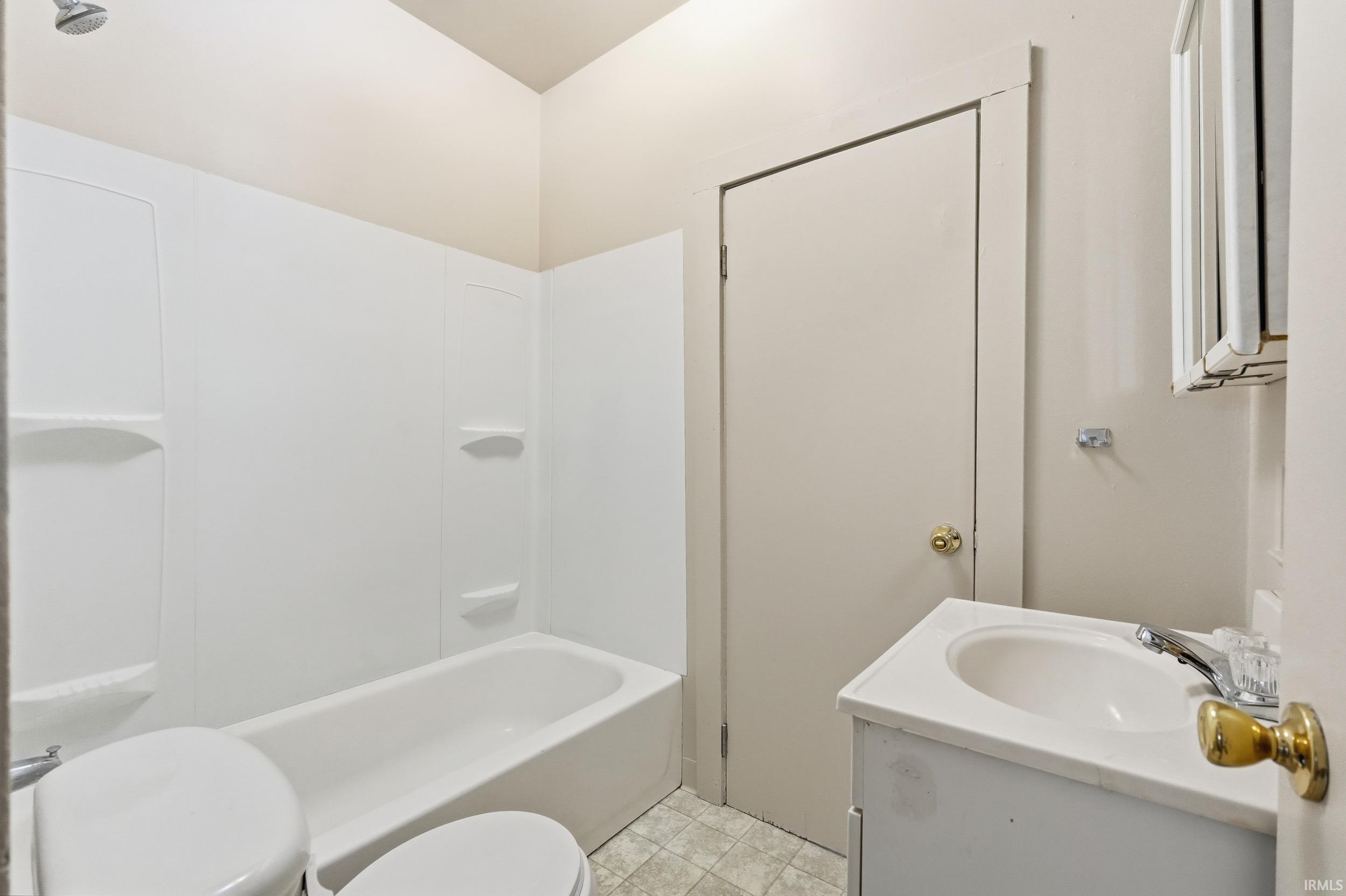 Bathroom featuring vanity, tub / shower combination, and light tile patterned floors