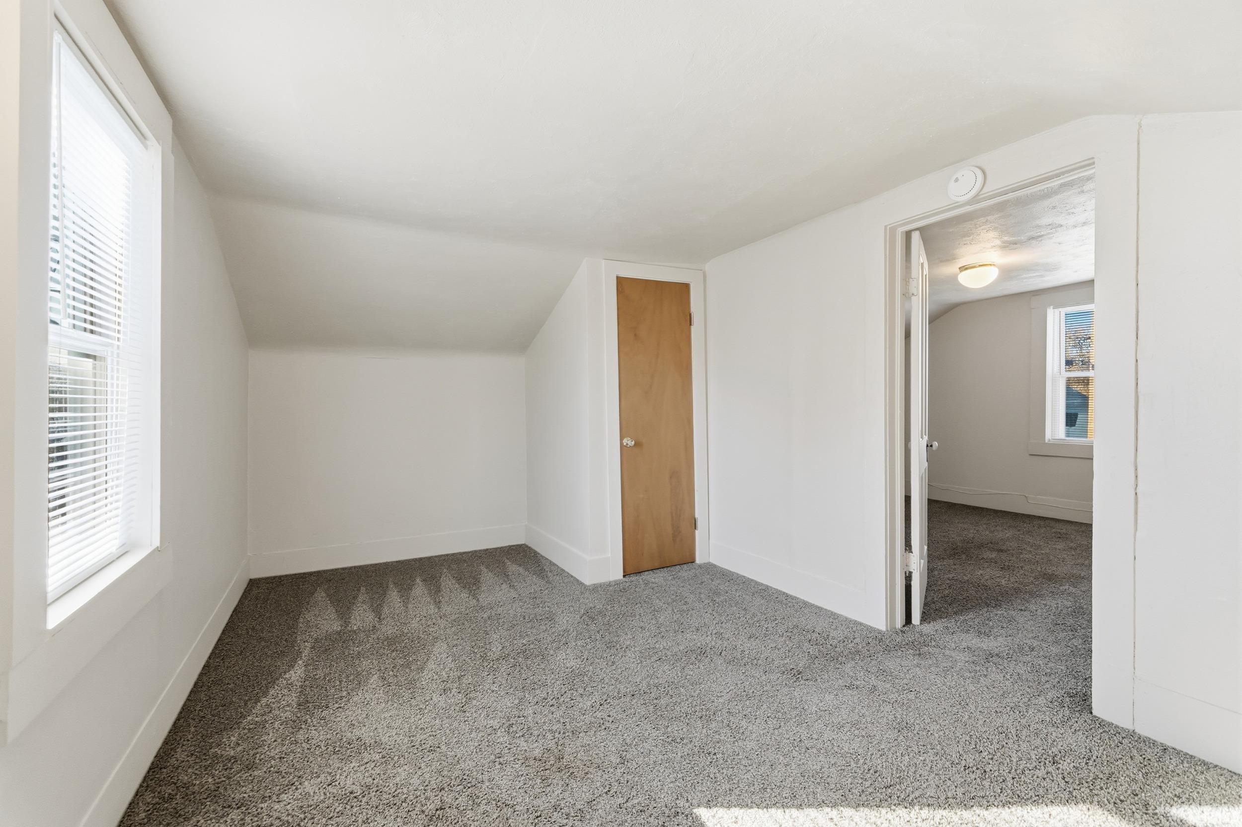 Bonus room with light colored carpet and lofted ceiling