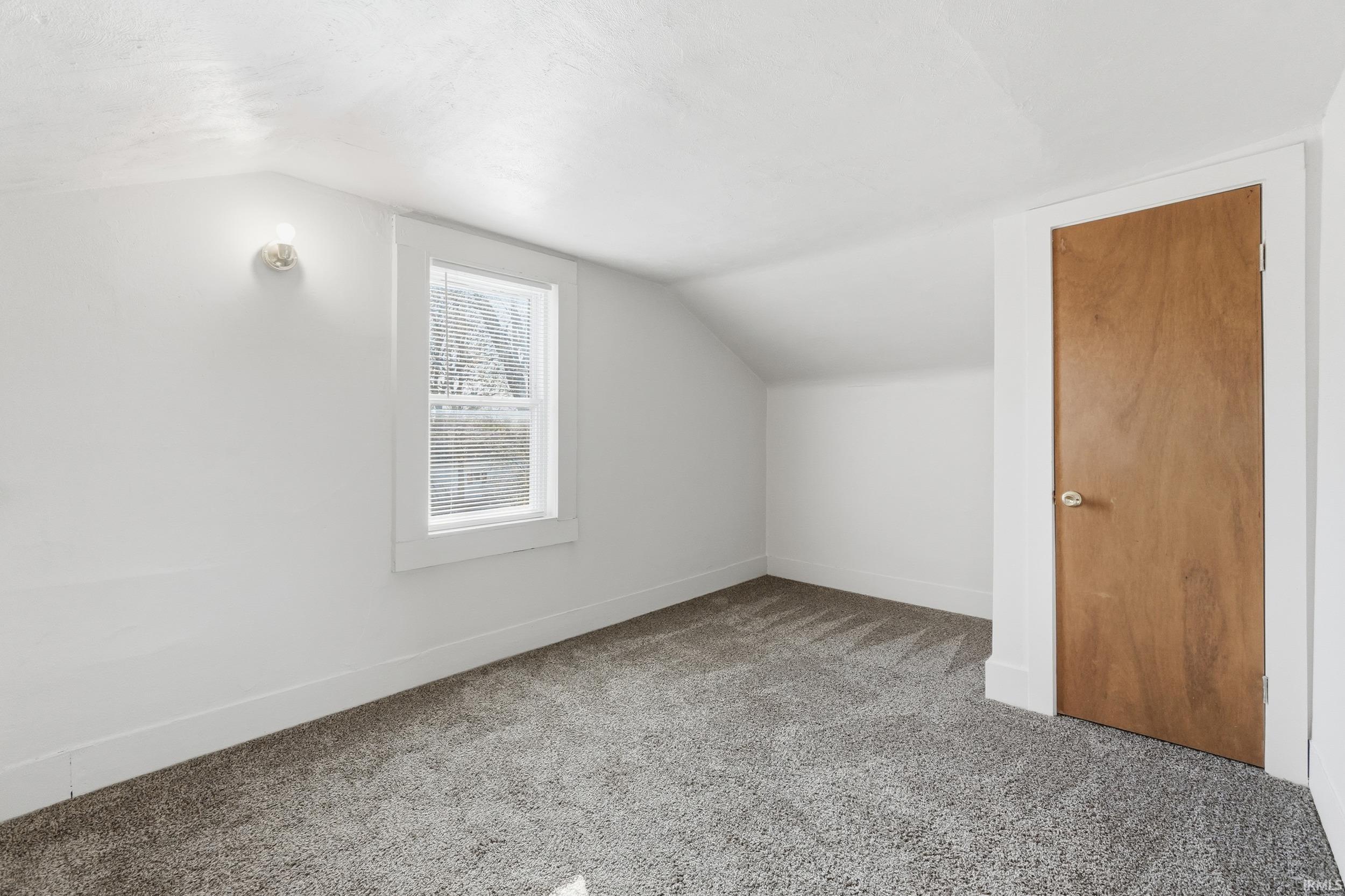 Bonus room featuring lofted ceiling and carpet