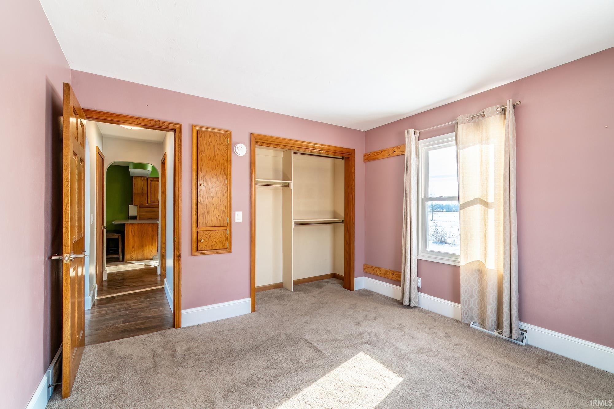 Unfurnished bedroom featuring carpet flooring, a closet, and arched walkways