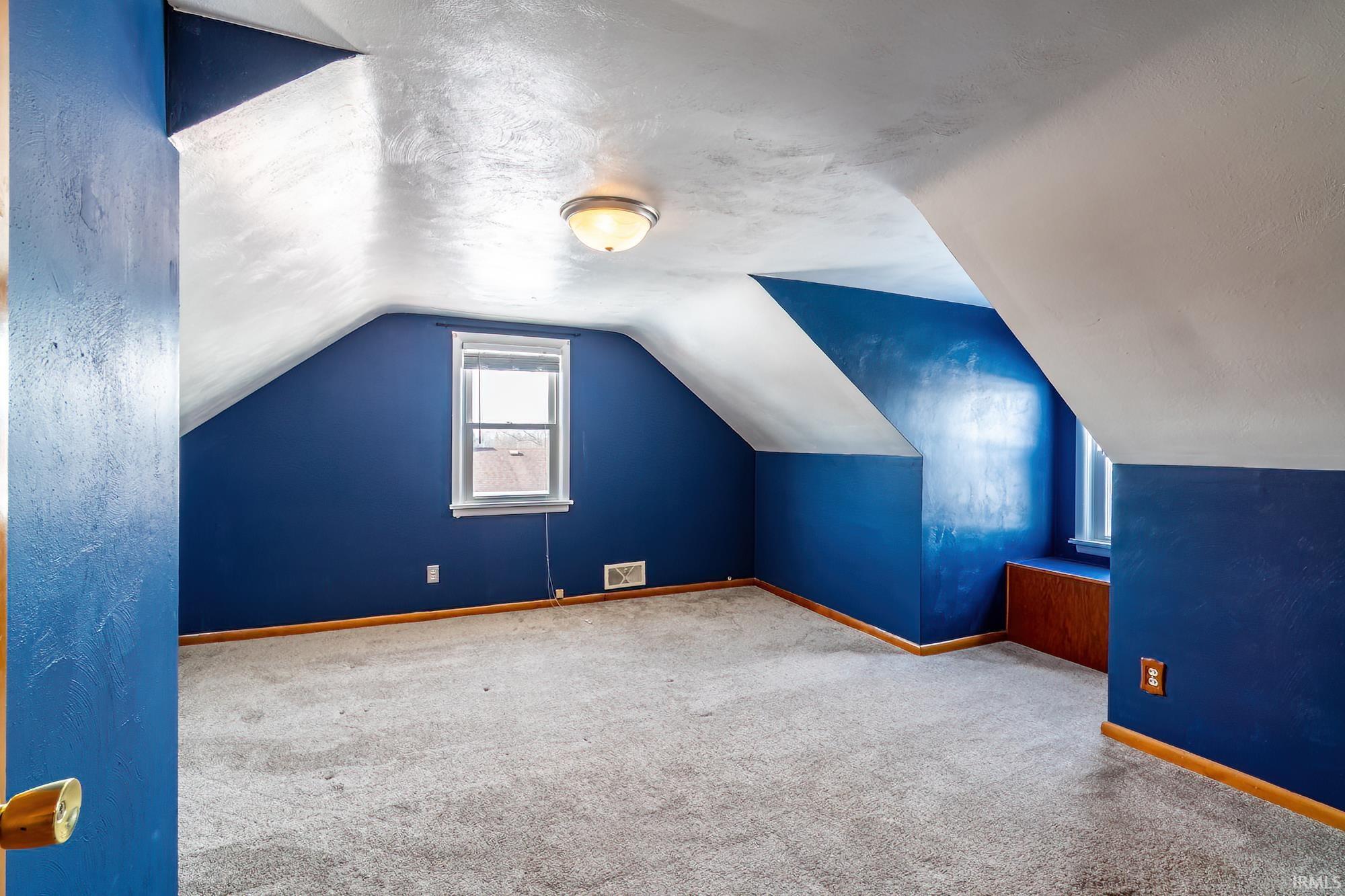 Bonus room with a textured ceiling, carpet flooring, and vaulted ceiling