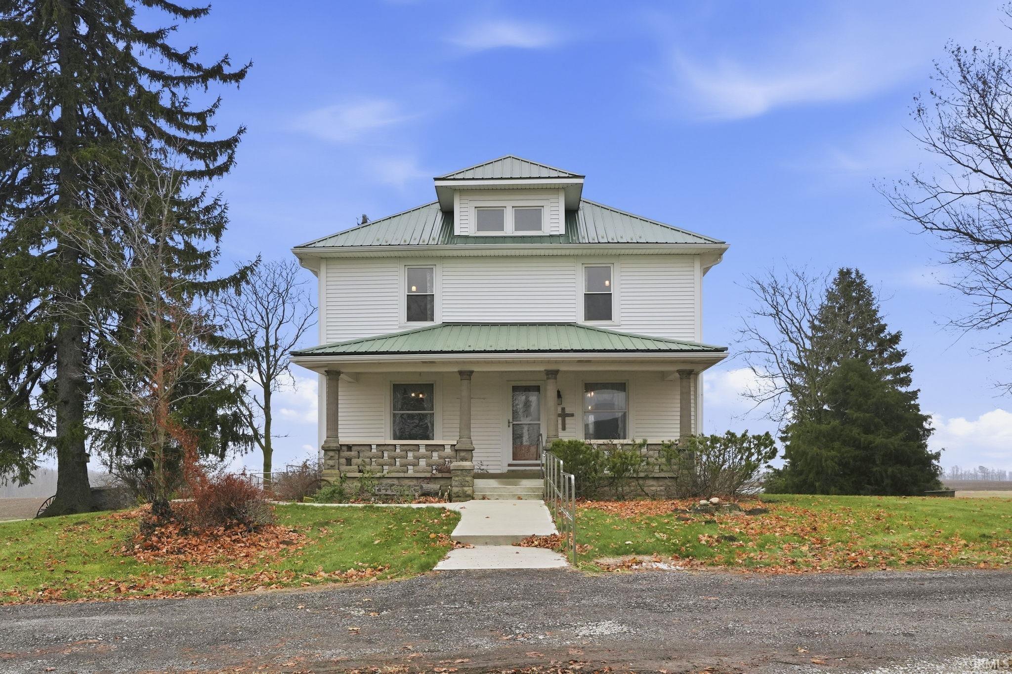 Traditional style home with a porch, a metal roof, and a front lawn