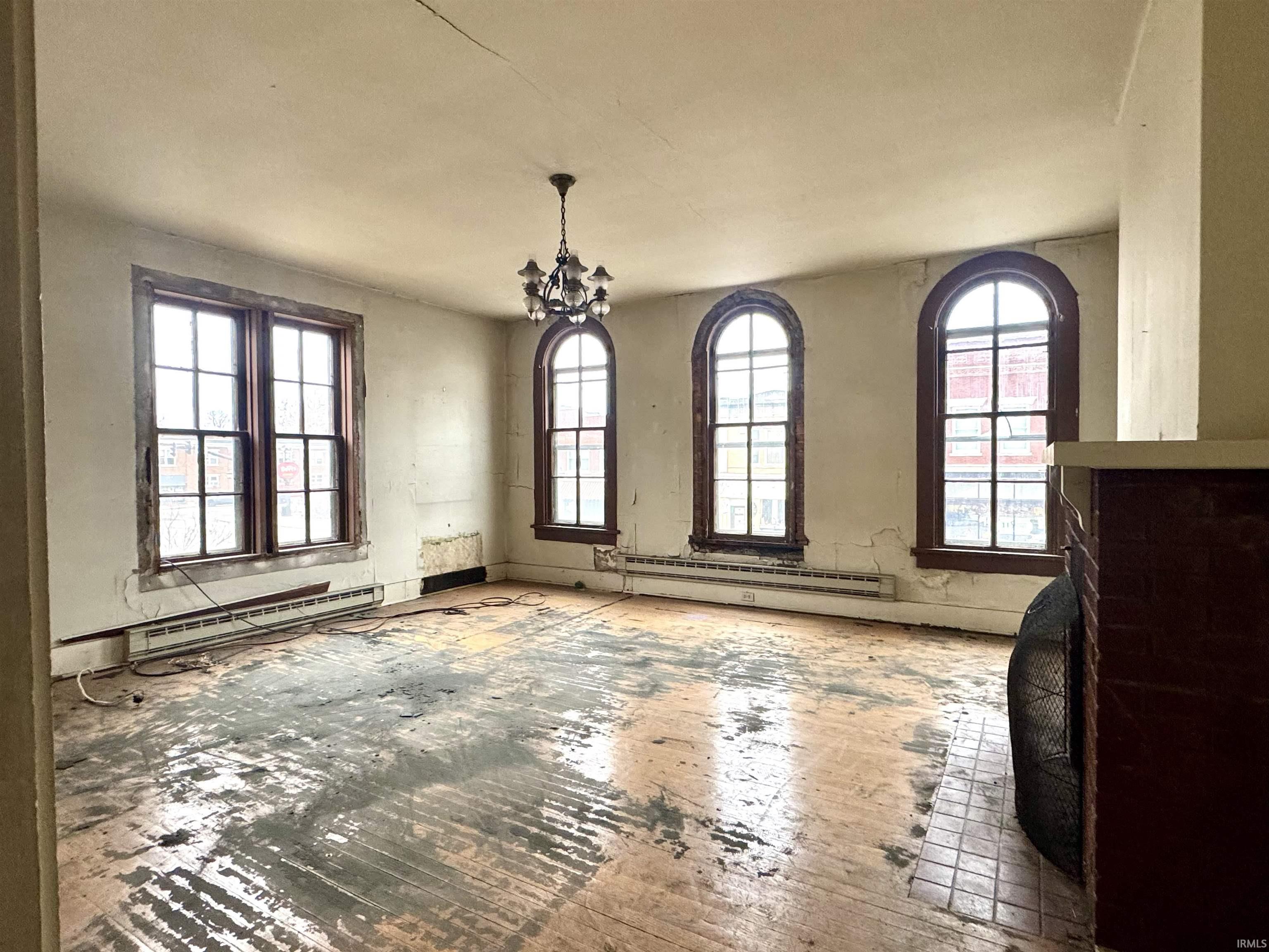 Unfurnished dining area featuring a baseboard radiator and a chandelier