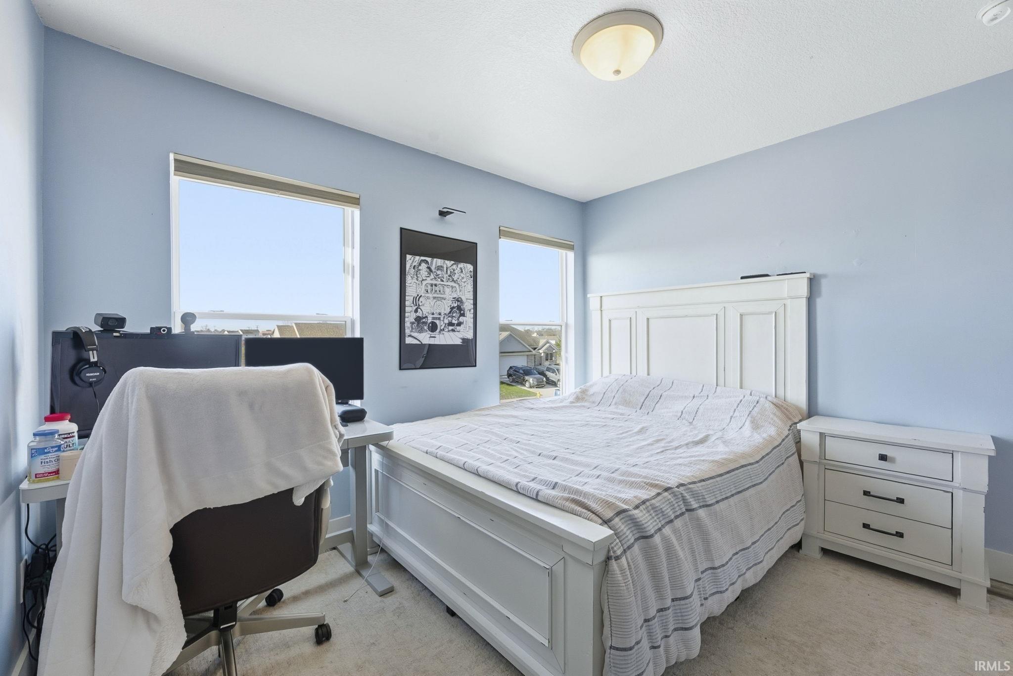 Bedroom featuring light colored carpet
