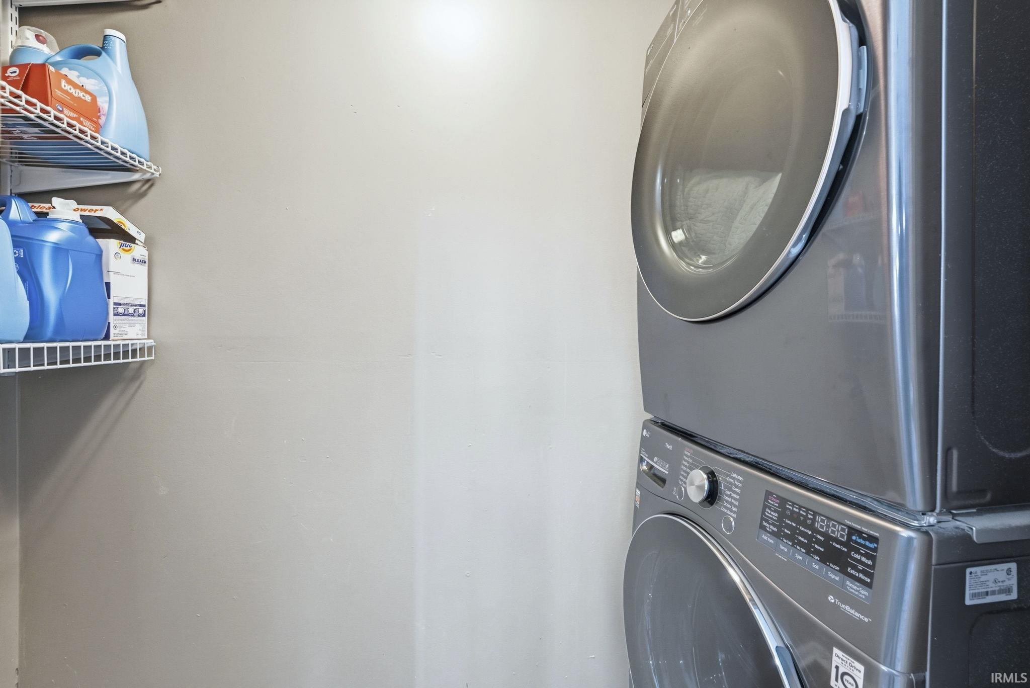Washroom featuring stacked washer / dryer