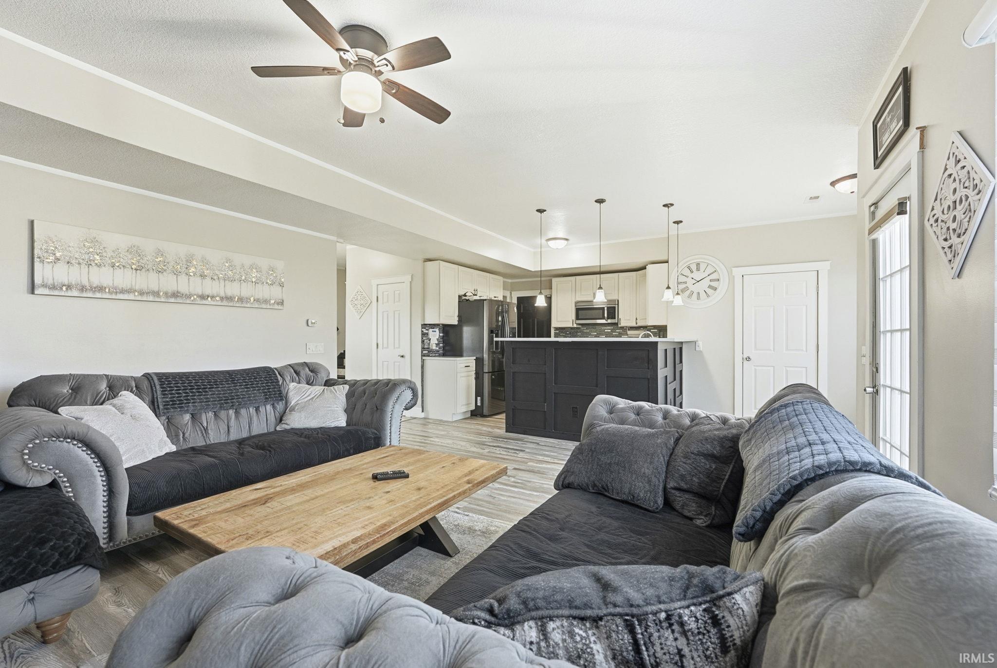 Living area with light wood-type flooring and ceiling fan