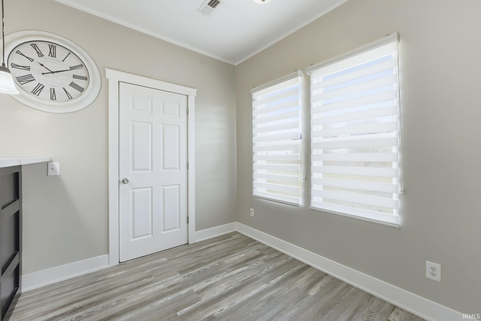 Unfurnished bedroom featuring light wood finished floors and crown molding