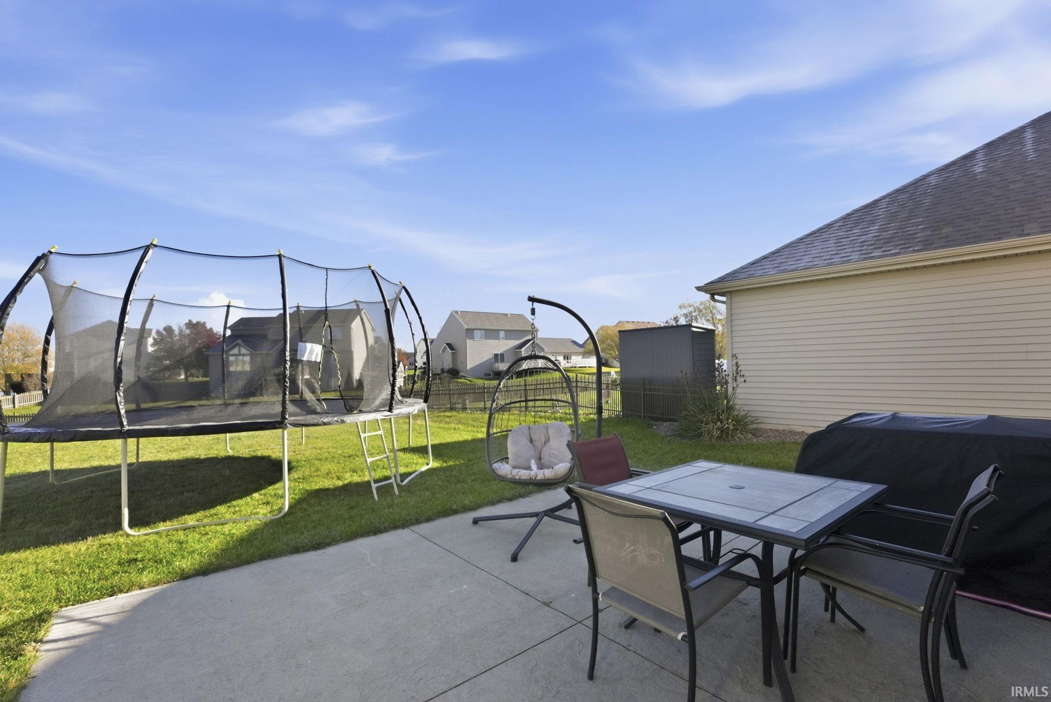 View of patio featuring a trampoline and outdoor dining space
