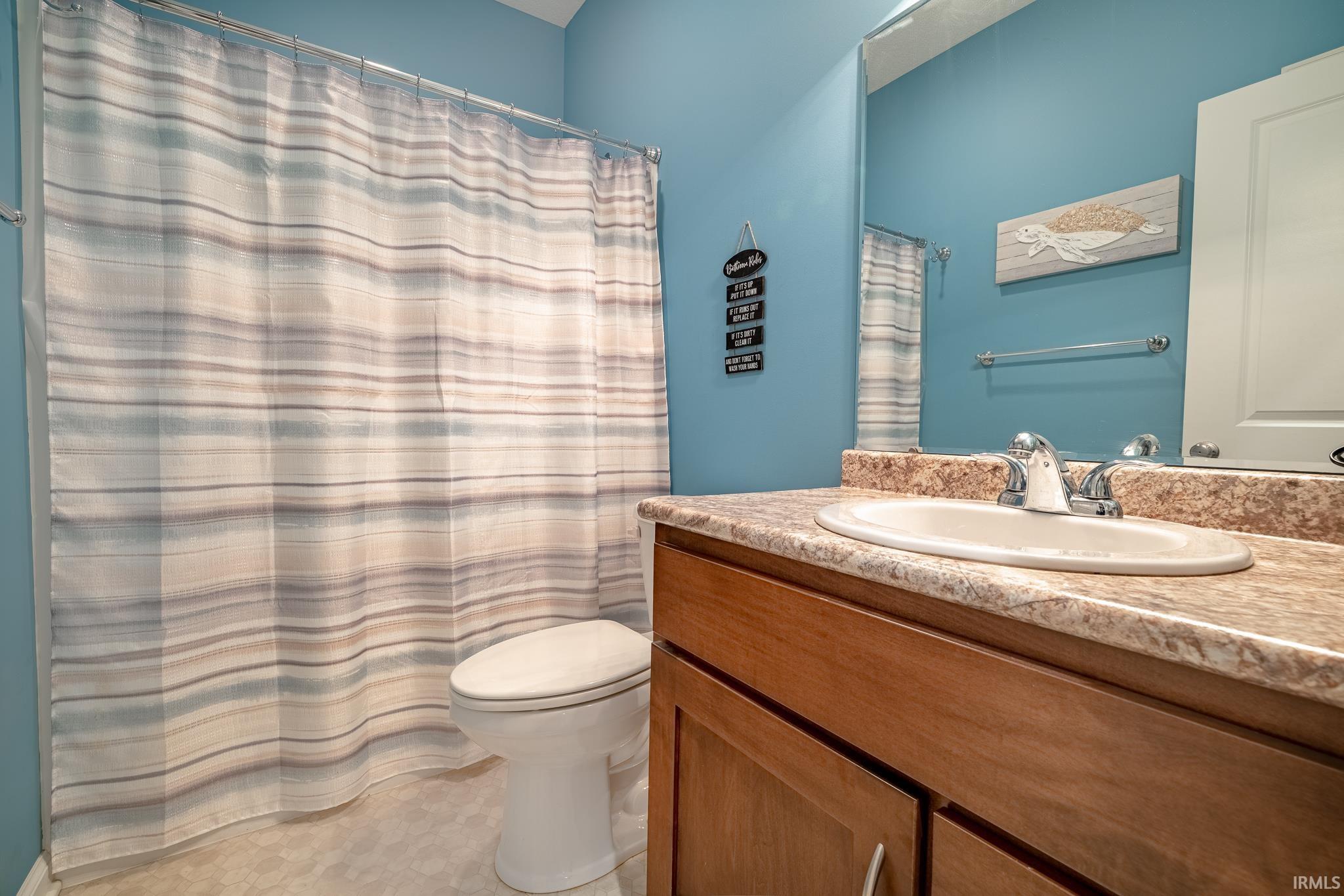 Bathroom with a shower with curtain and vanity