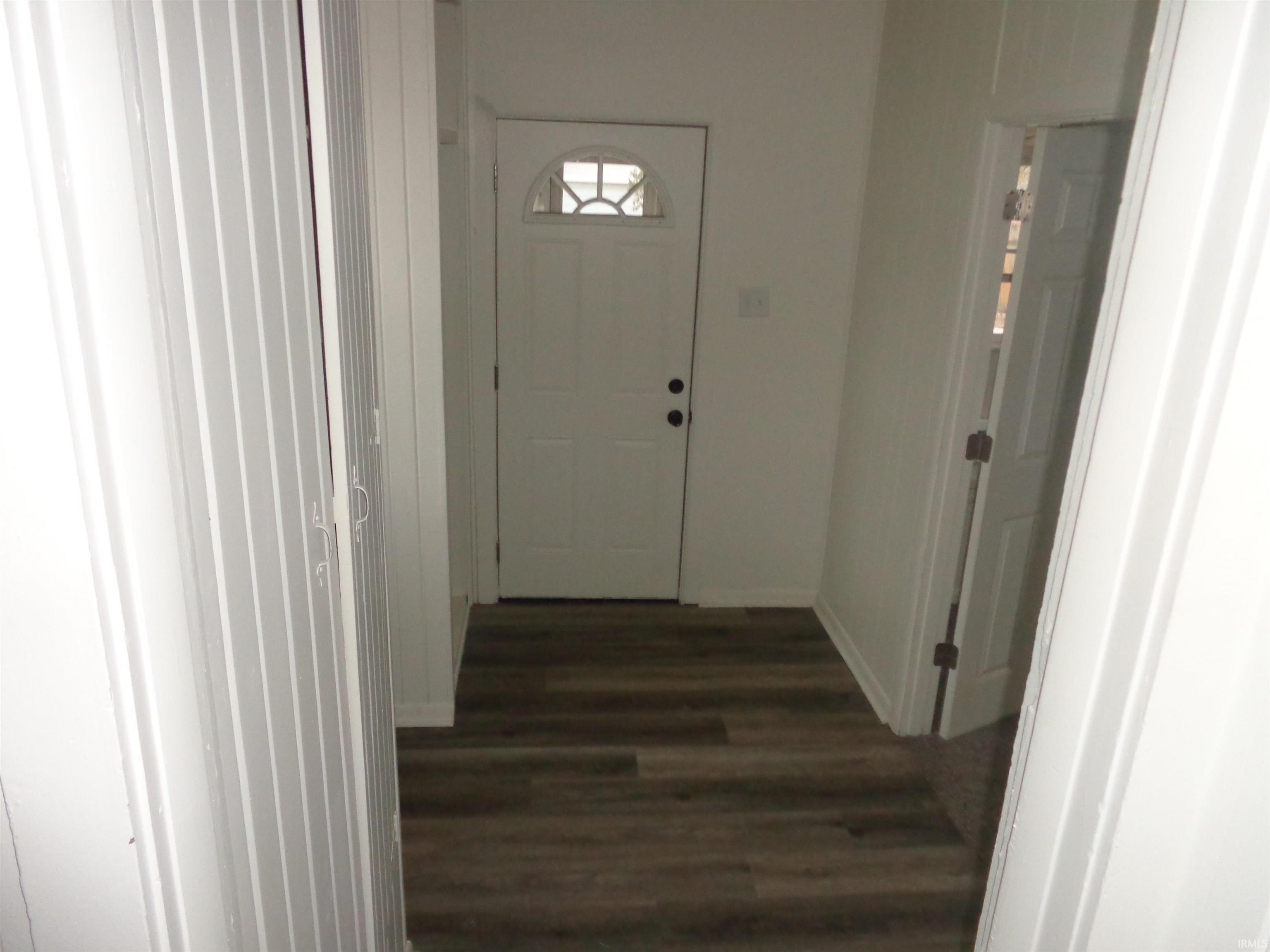 Entryway featuring baseboards and wood finished floors
