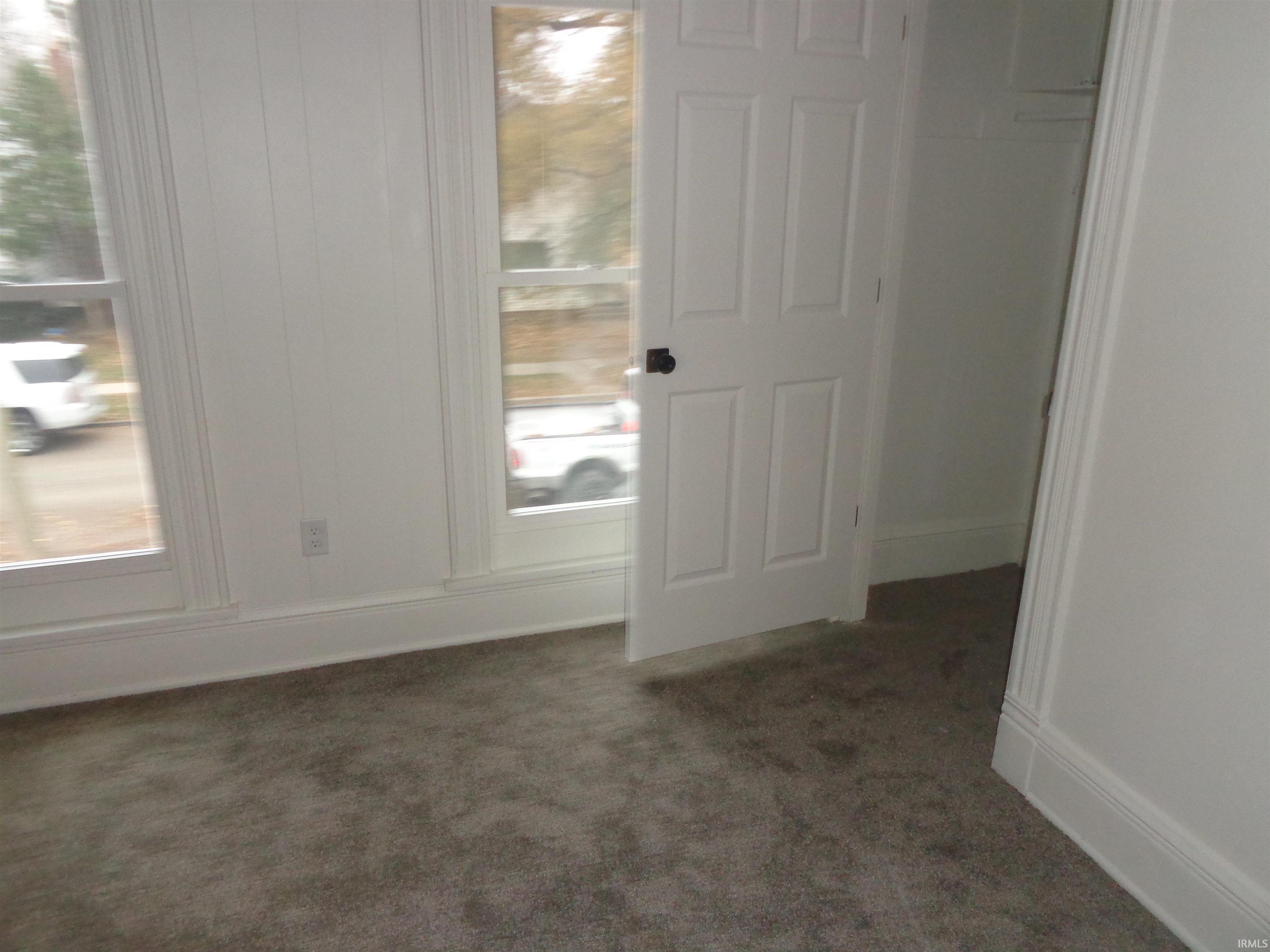 Entryway featuring dark carpet and baseboards
