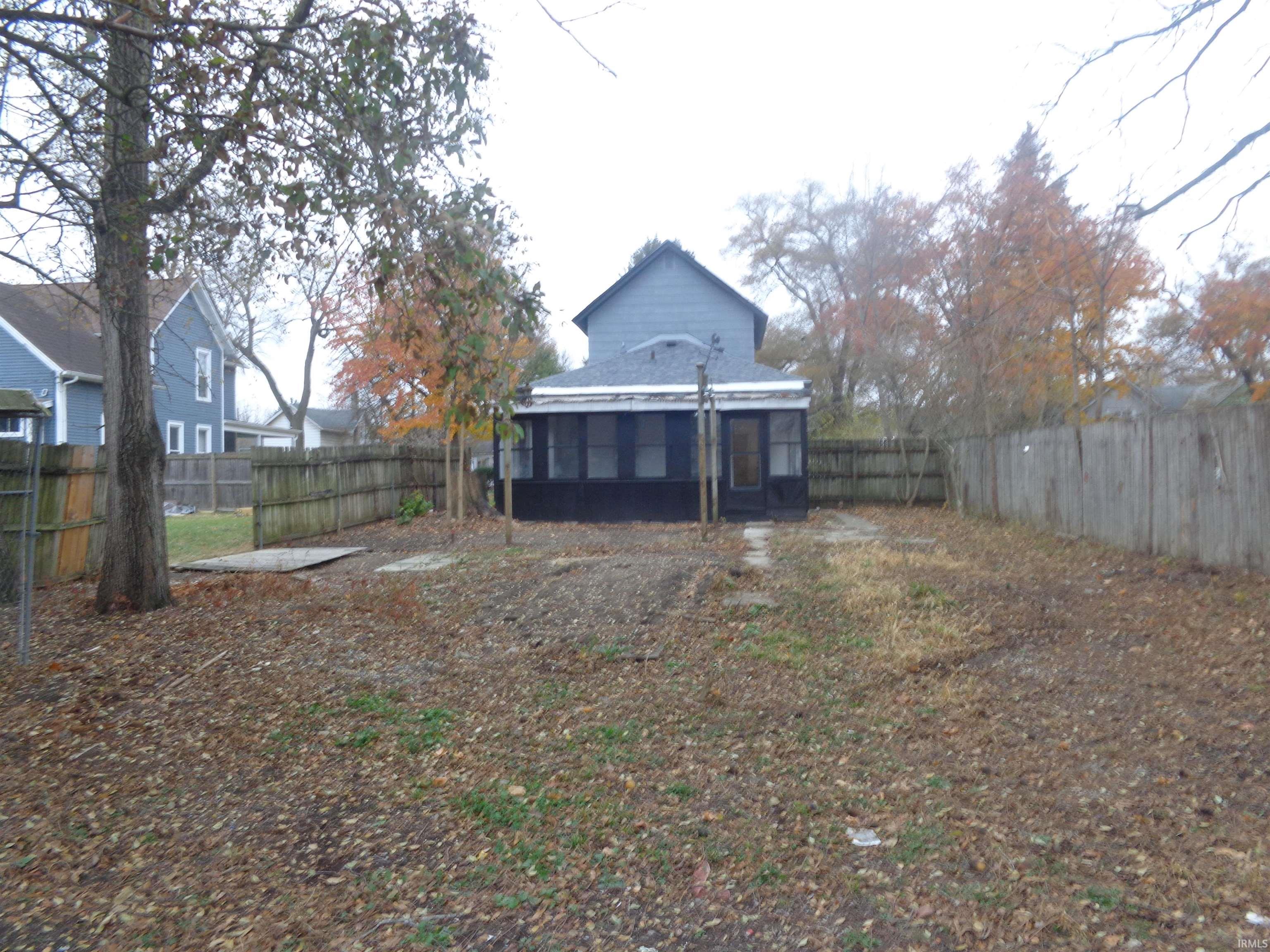 Rear view of house featuring a sunroom and a fenced backyard