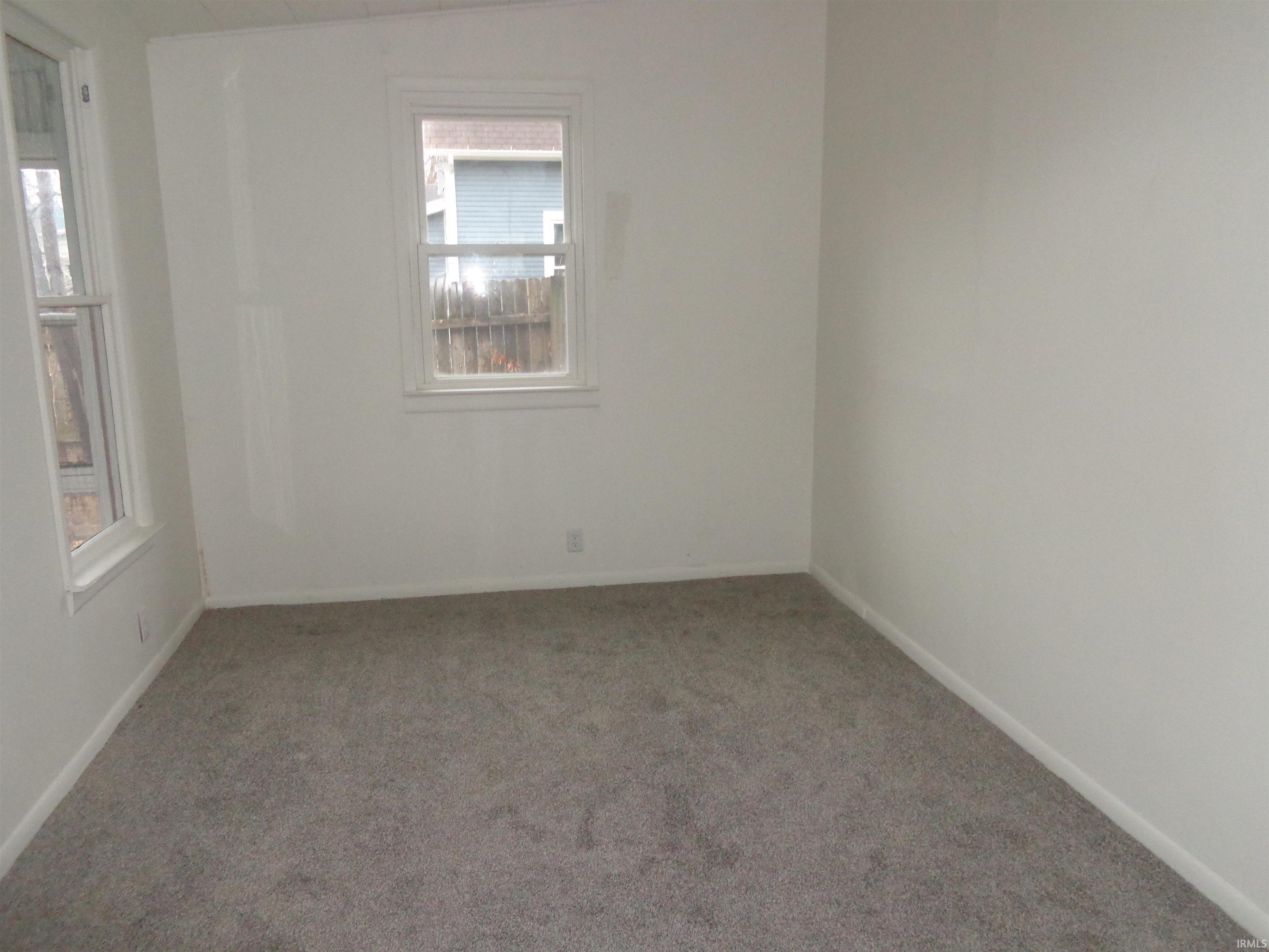 Carpeted empty room featuring baseboards