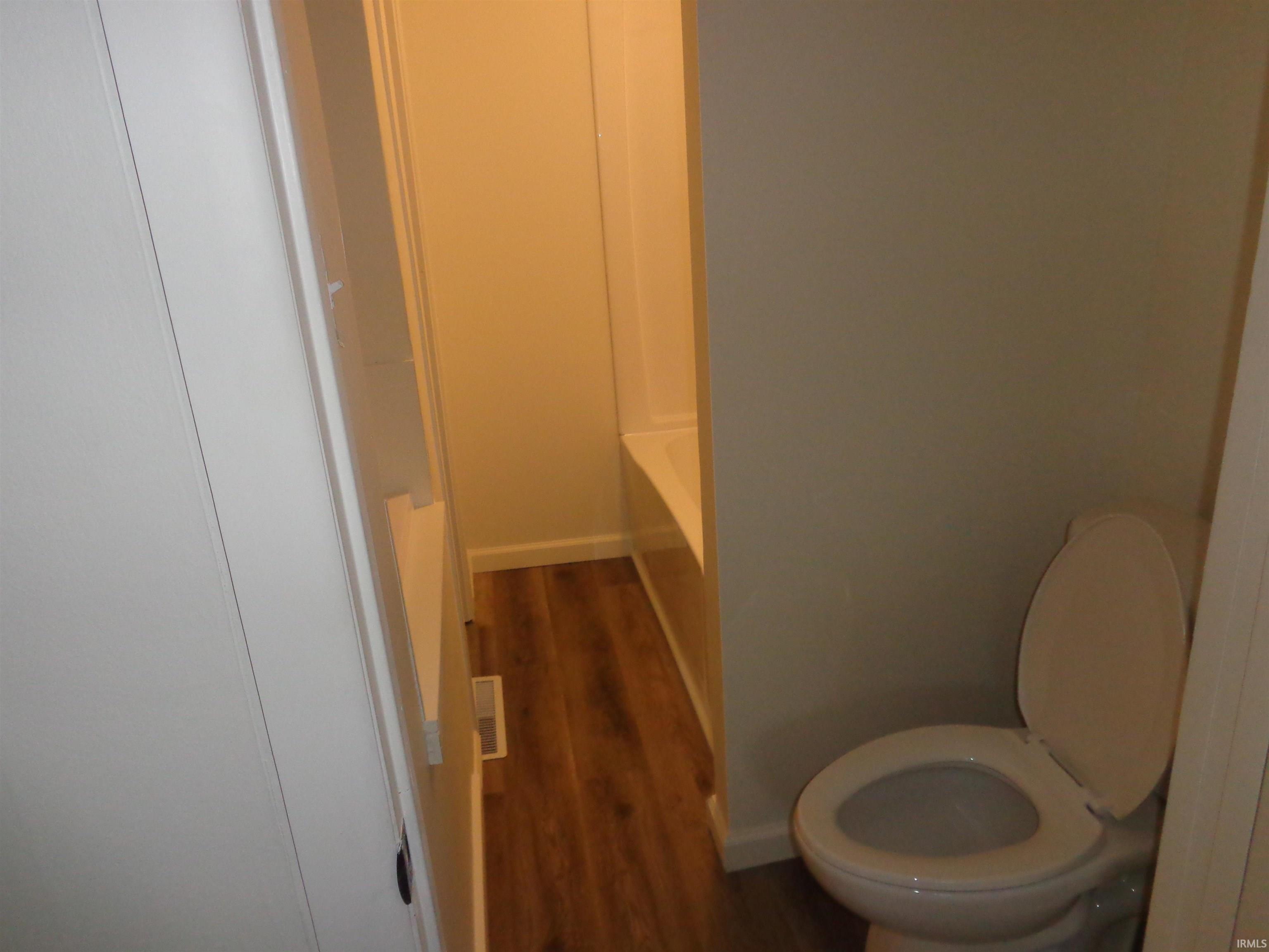 Bathroom featuring dark wood-style flooring and a bathtub